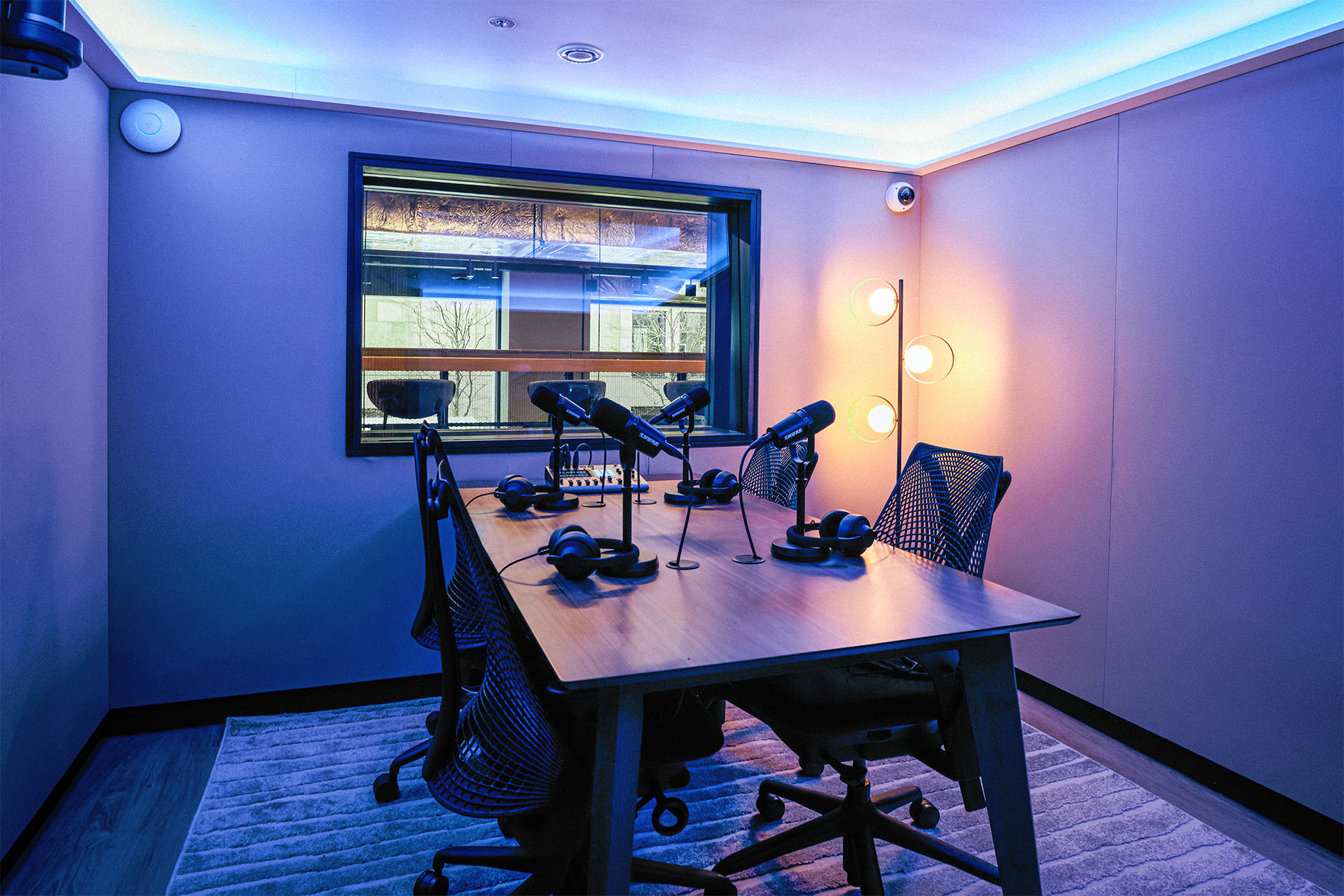 Modern podcast room with sleek table, microphones for creative collaboration and conferences.