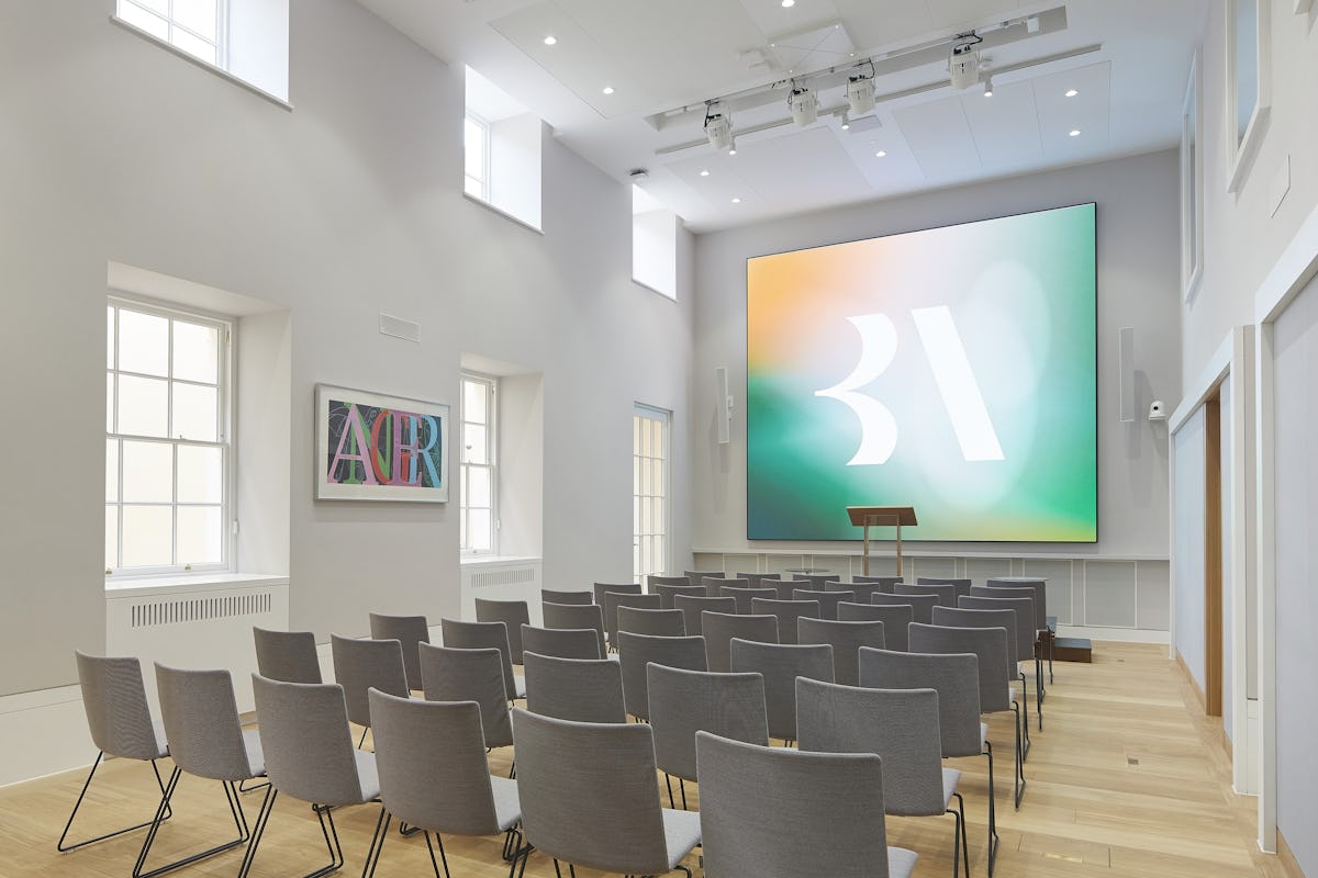 Theater-style corporate conference room with modern-heritage design for keynote presentations.