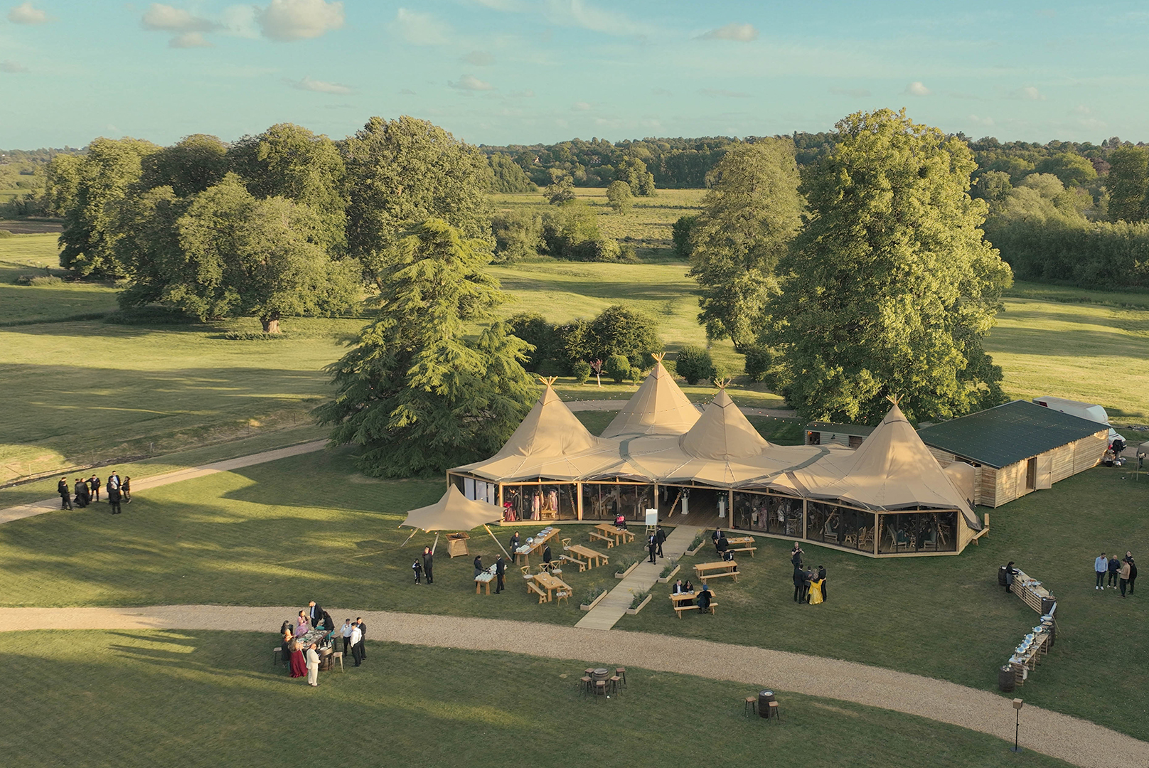 Linked tipis at Mapledurham venue, rustic-chic outdoor setting for corporate retreats or weddings.