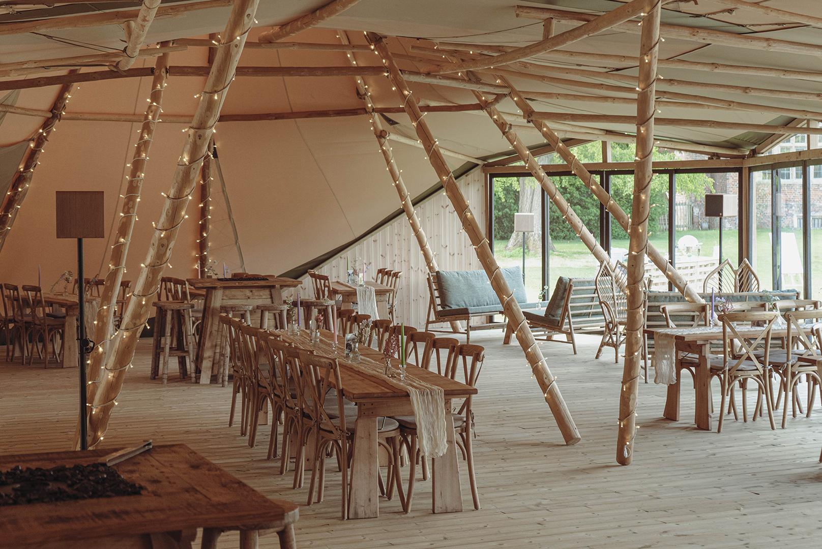 Bohemian tipi venue with warm string lighting for rustic weddings and corporate retreats.