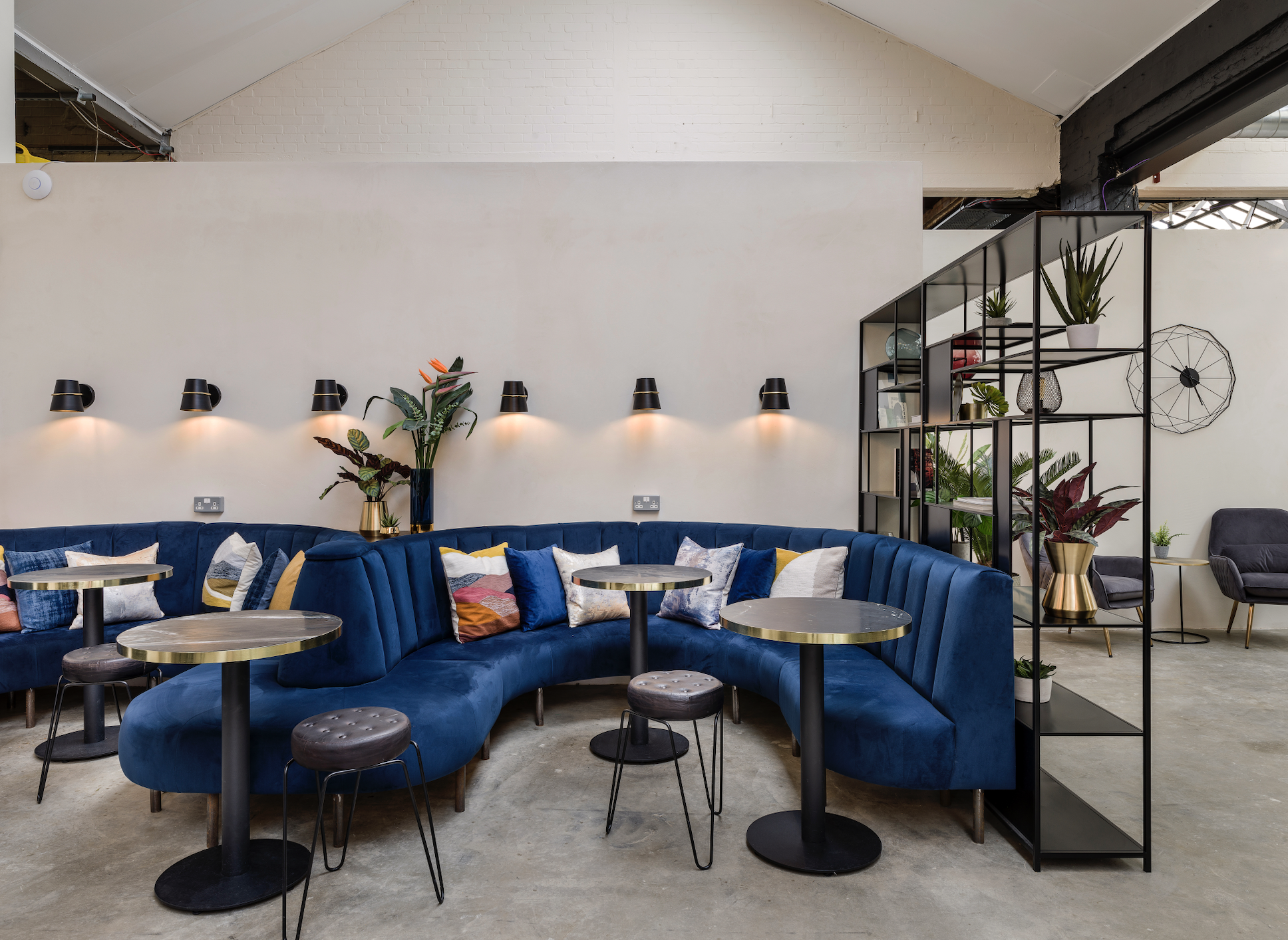 Stylish event space with curved blue seating for networking in West London.