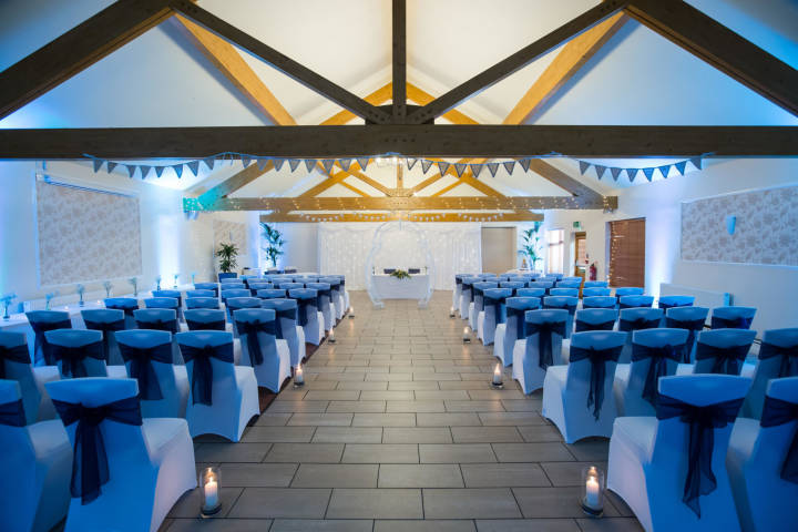 Phoenix Suite wedding ceremony with vaulted ceilings, elegant aisle lighting, and theater seating.