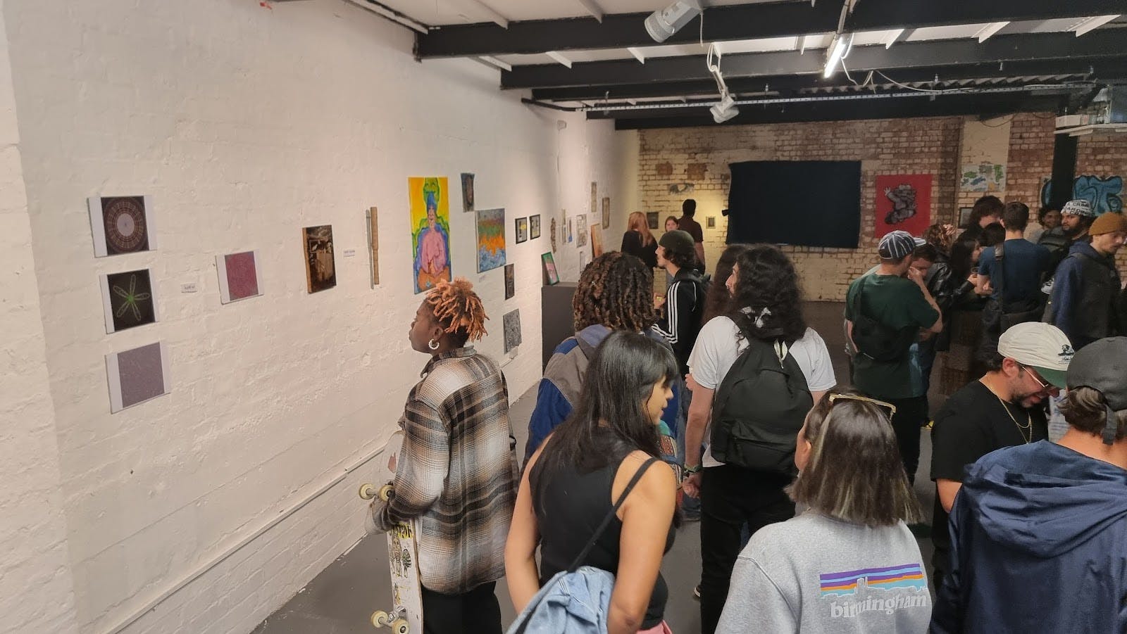 Industrial Stryx art gallery hosting a crowded pop-up reception.