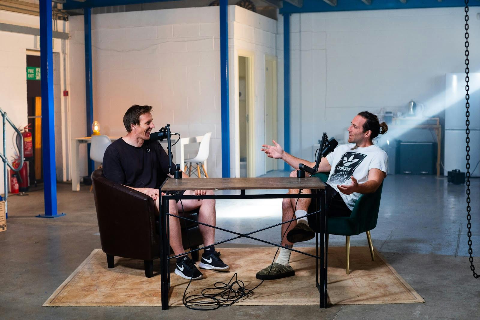 Minimalist podcast studio setup in industrial venue for hybrid content production.