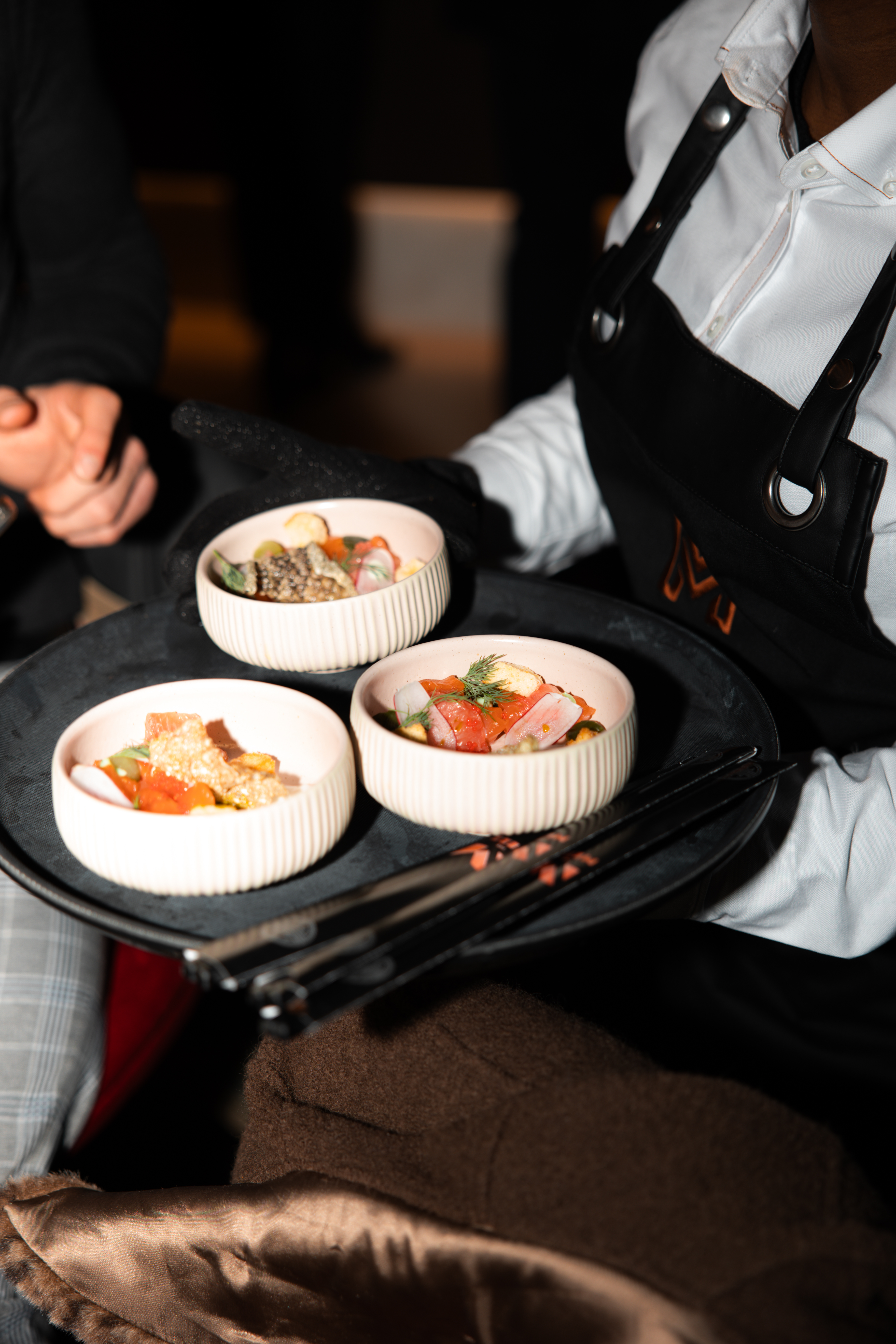 Gourmet dishes on a black tray at The Mezz, AO Arena for upscale events.