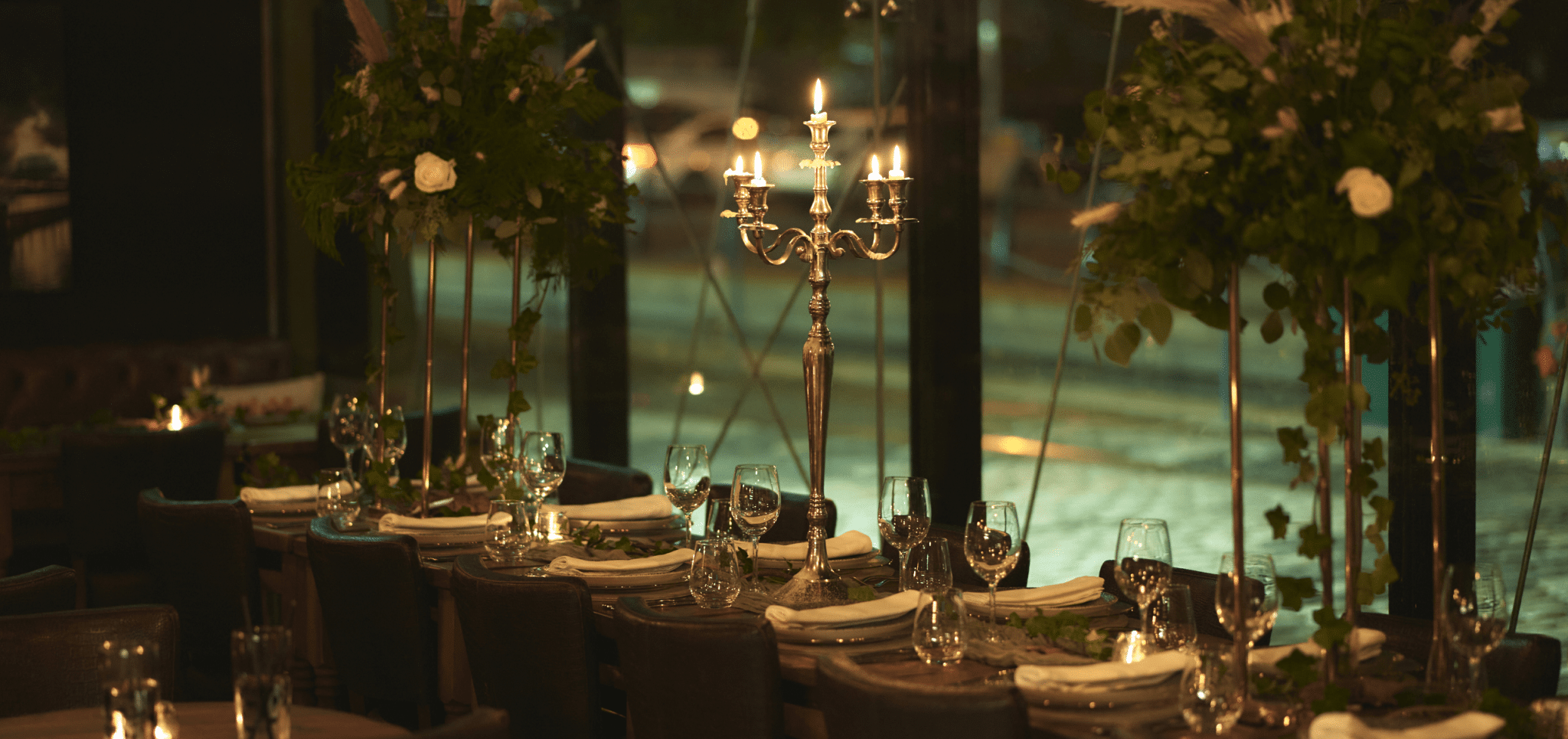 Gala event space at Season Quayside with elegant floral arrangements and silver candelabra.