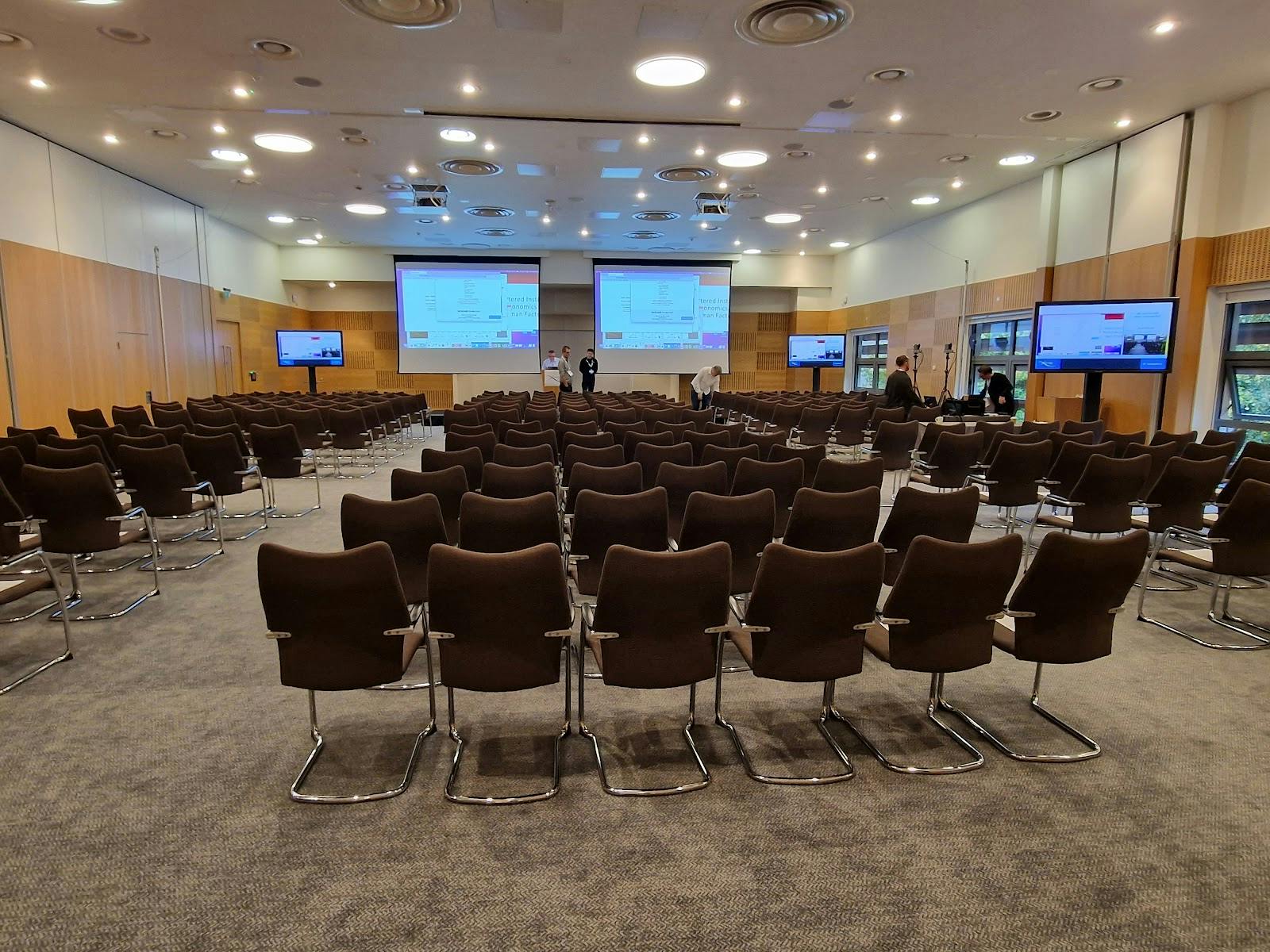 Theater-style plenary room with dual screens for large conferences and keynote presentations.