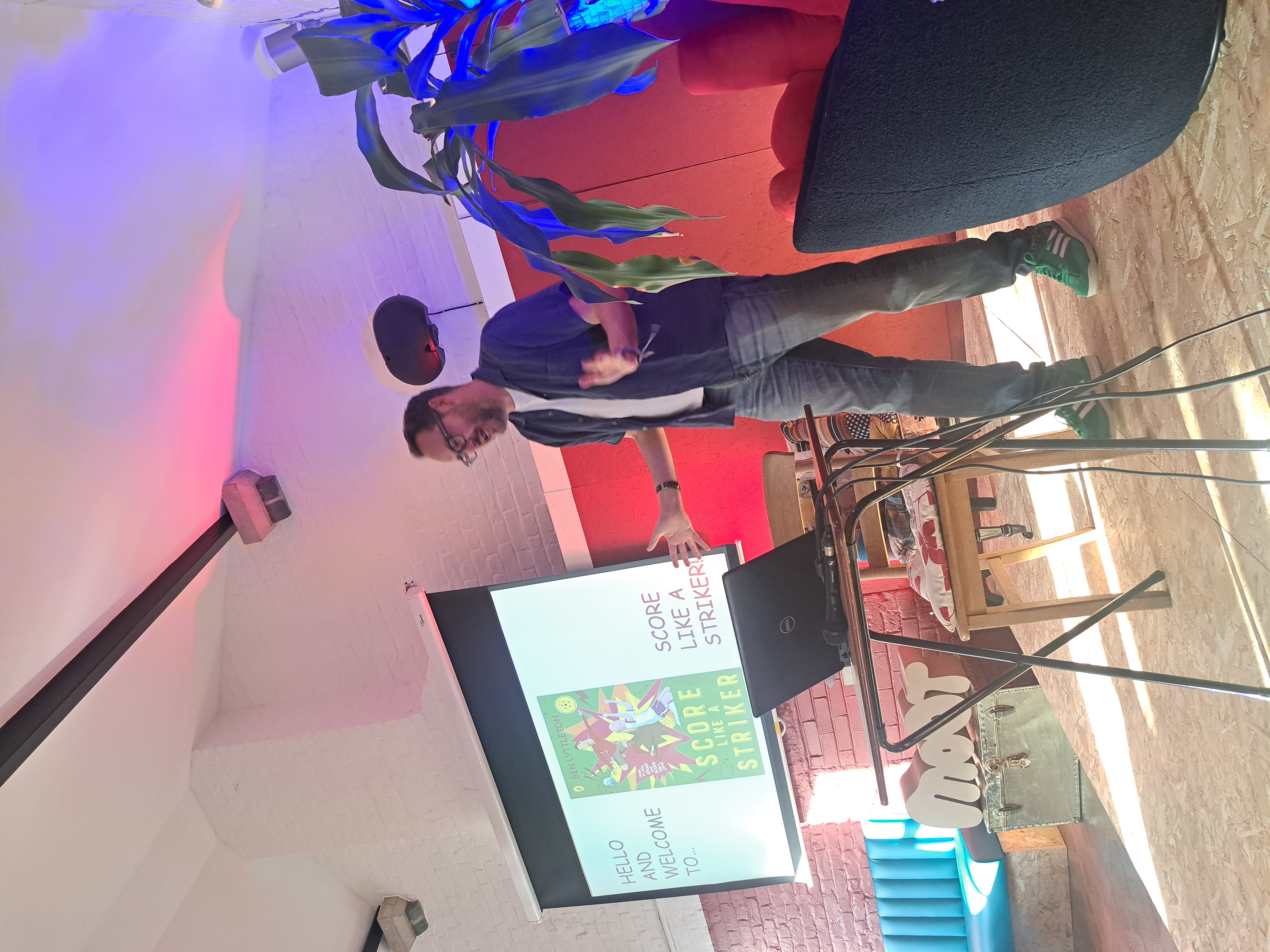 Workshop speaker in industrial Moot event space with atmospheric lighting for corporate seminars.