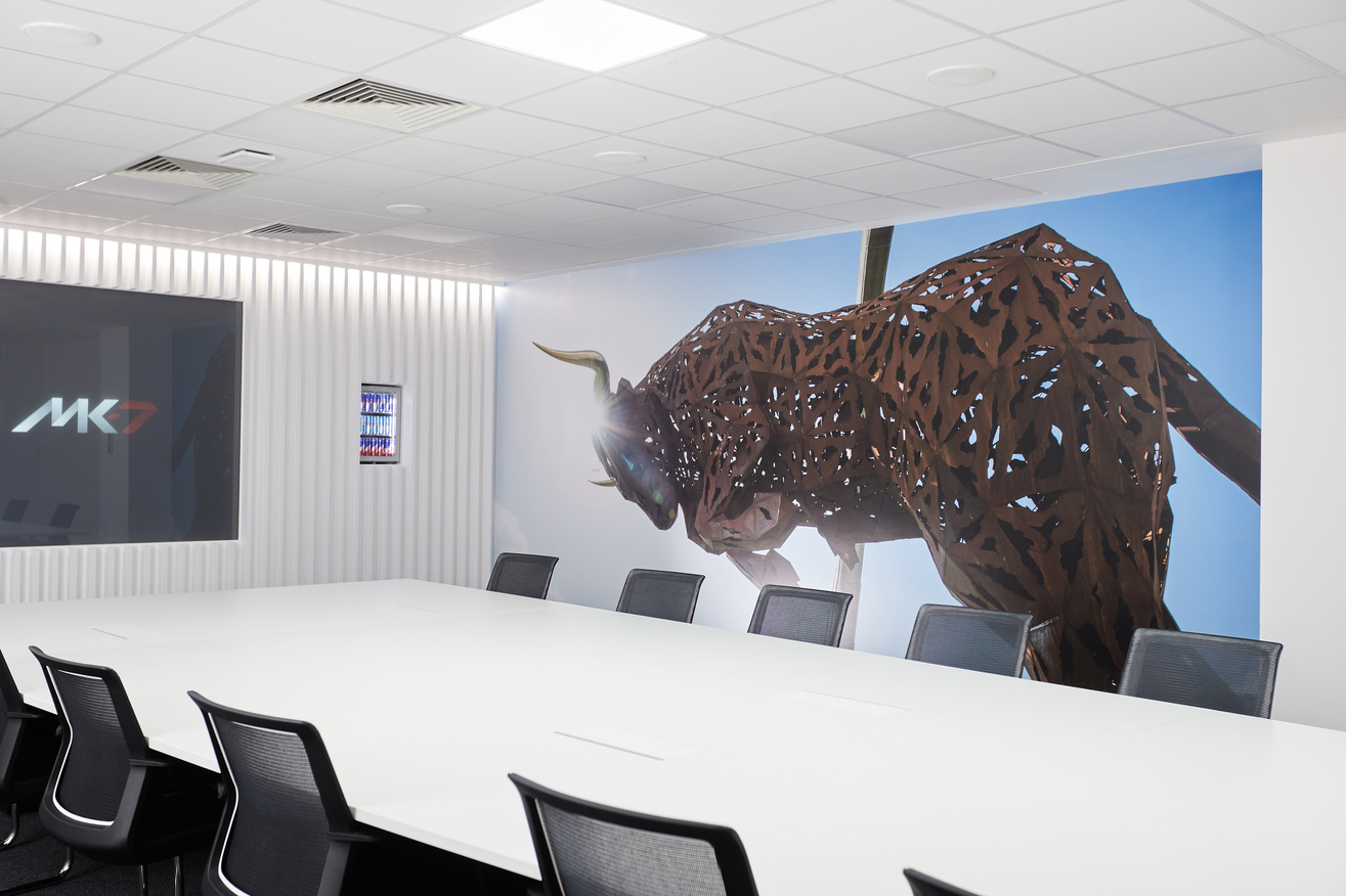 Red Bull Racing Boardroom with a white conference table and abstract bull mural, ideal for meetings.