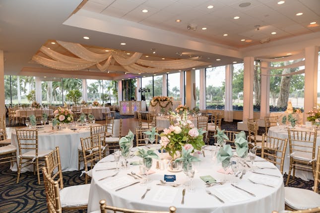 Elegant Jacaranda Club wedding reception with gold Chiavari chairs and scenic golf course views.