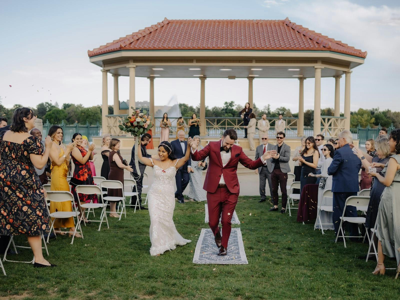 Outdoor wedding recessional at City Park Pavilion, featuring elegant architectural focal point.