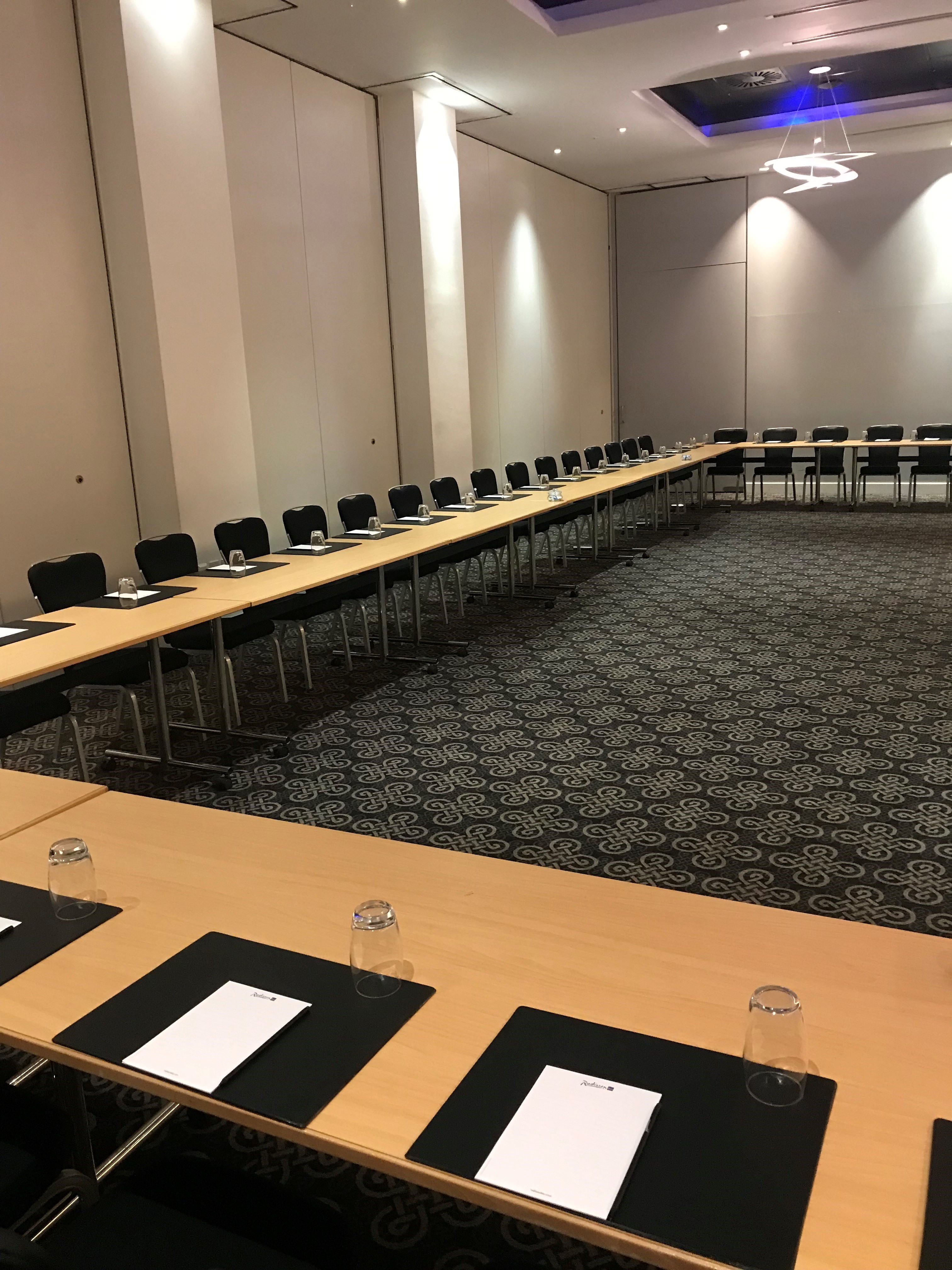 Azzurro Ballroom meeting setup with long table, ideal for workshops and strategic planning.