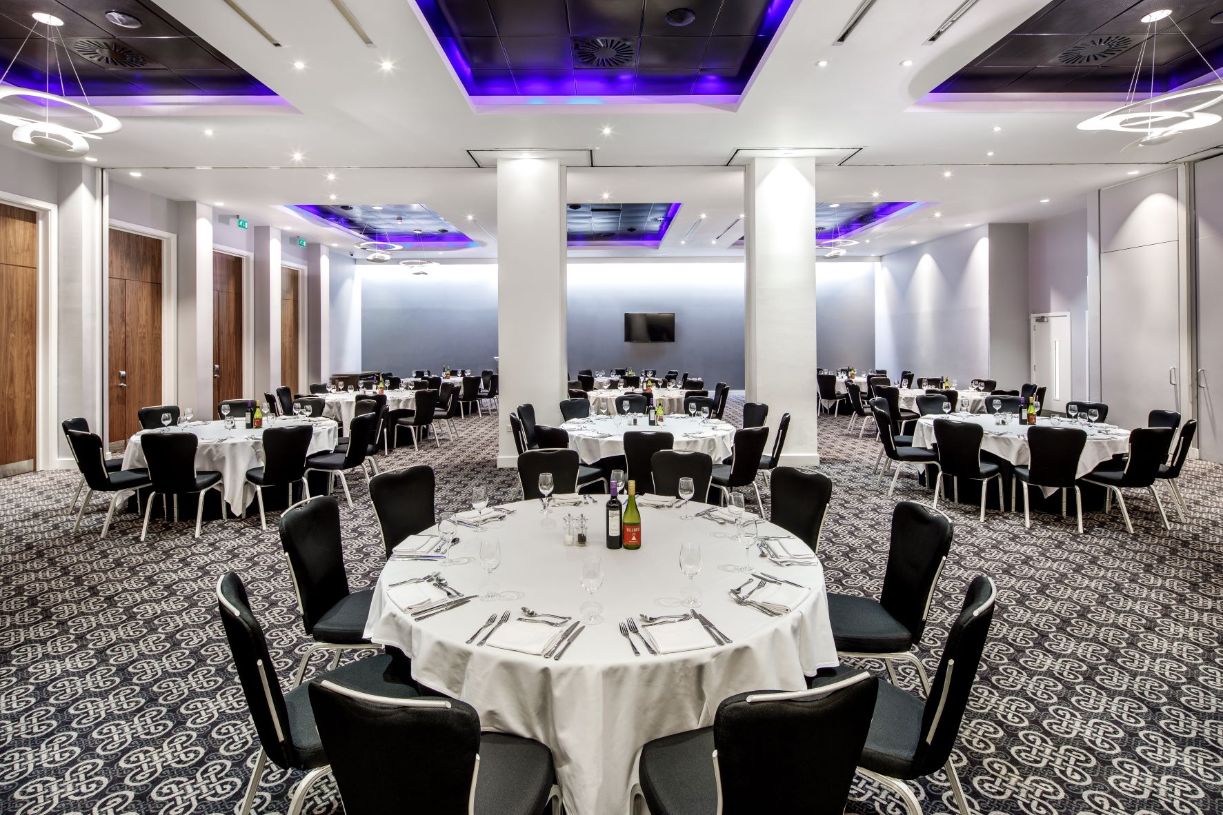 Azzurro Ballroom at Radisson Blu Cardiff, elegant banquet setup with ambient lighting.