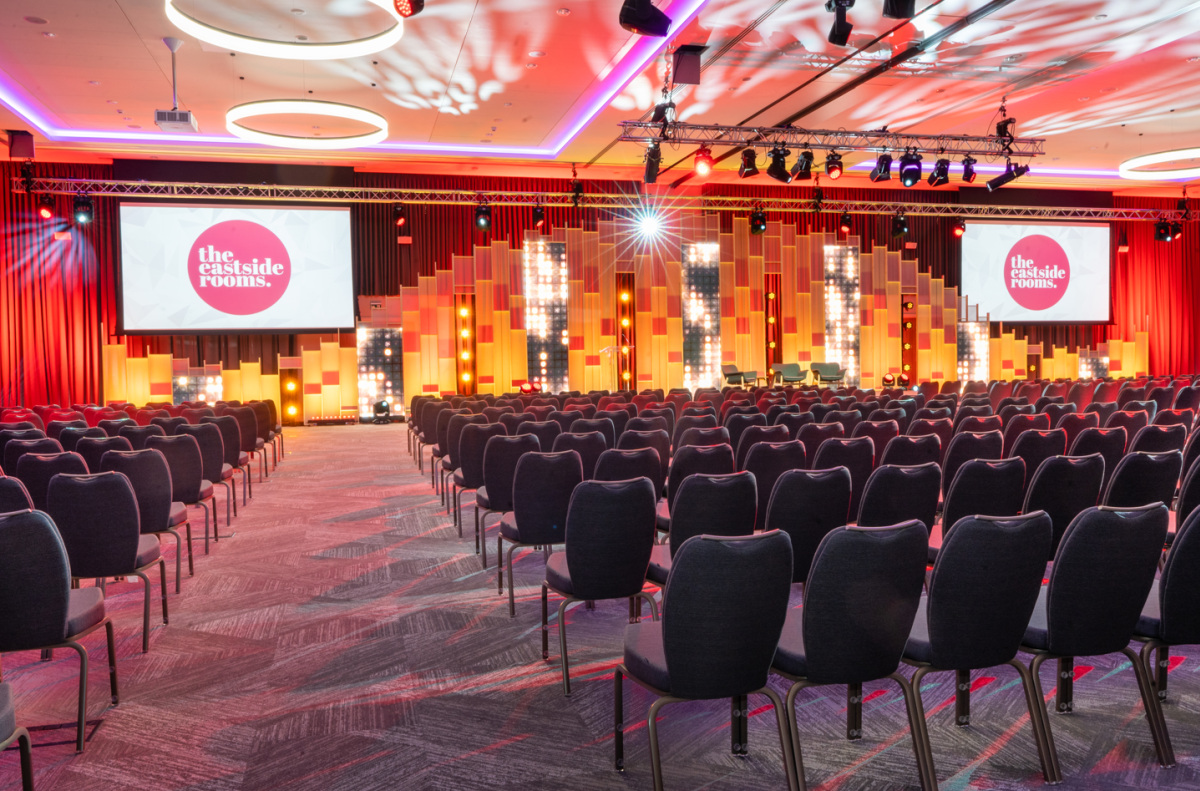 Aloft Birmingham Eastside meeting room with tiered stage for corporate events and conferences.