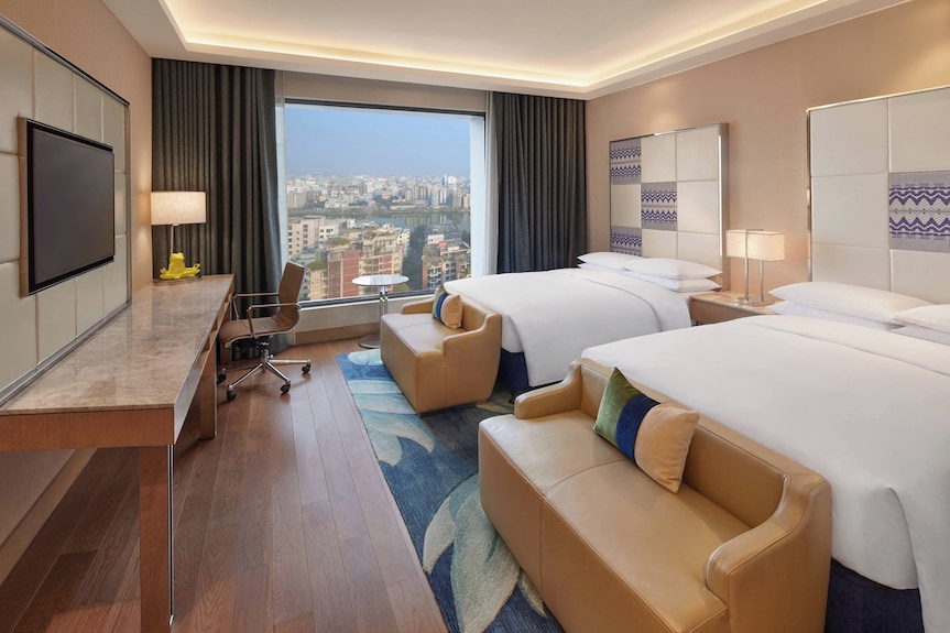 Premium double-queen suite with workspace and city views, ideal for business travel and conferences.