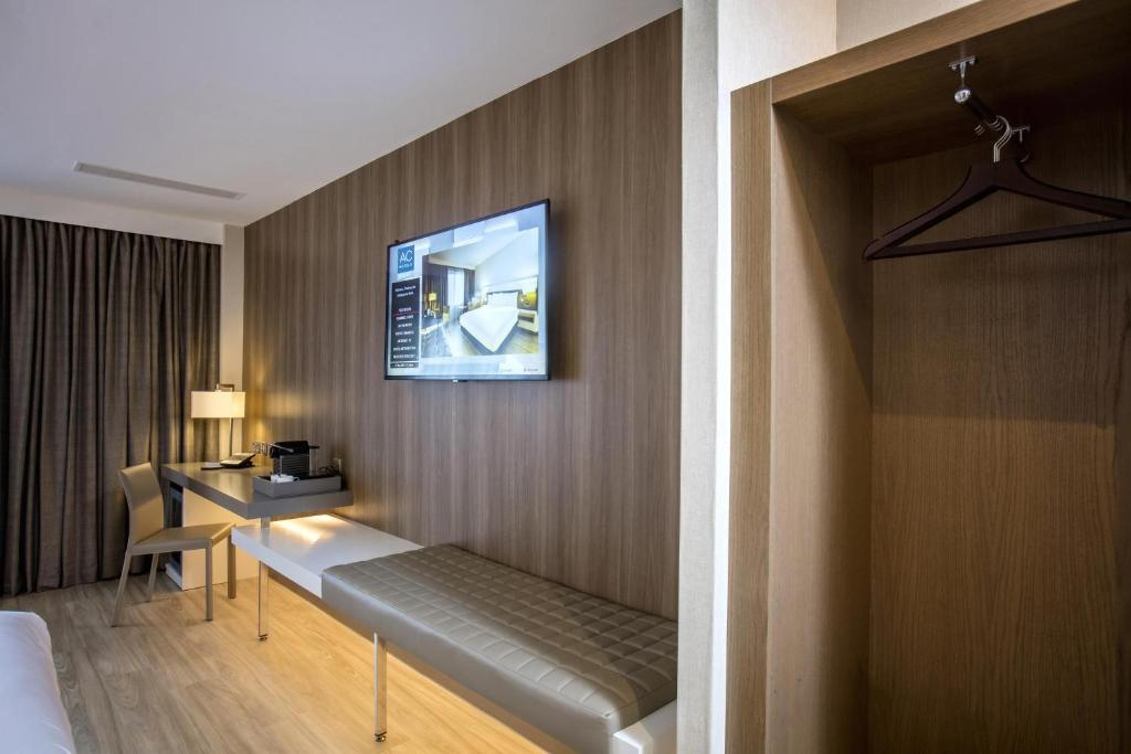 Modern AC Hotel suite with workstation, ideal for business travel and conference lodging.