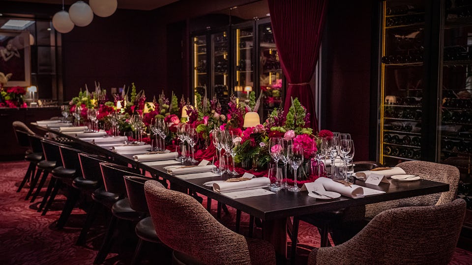 Elegant private dining setup with floral arrangements for gala or corporate events.