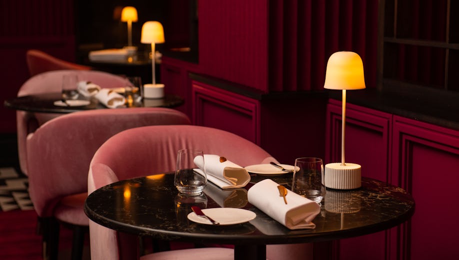 Elegant restaurant dining setup with pink upholstery for intimate events and gatherings.