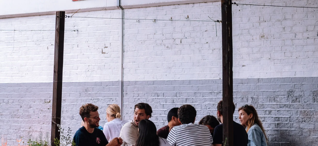Industrial-chic event venue with white brick wall for networking and corporate breakout sessions.