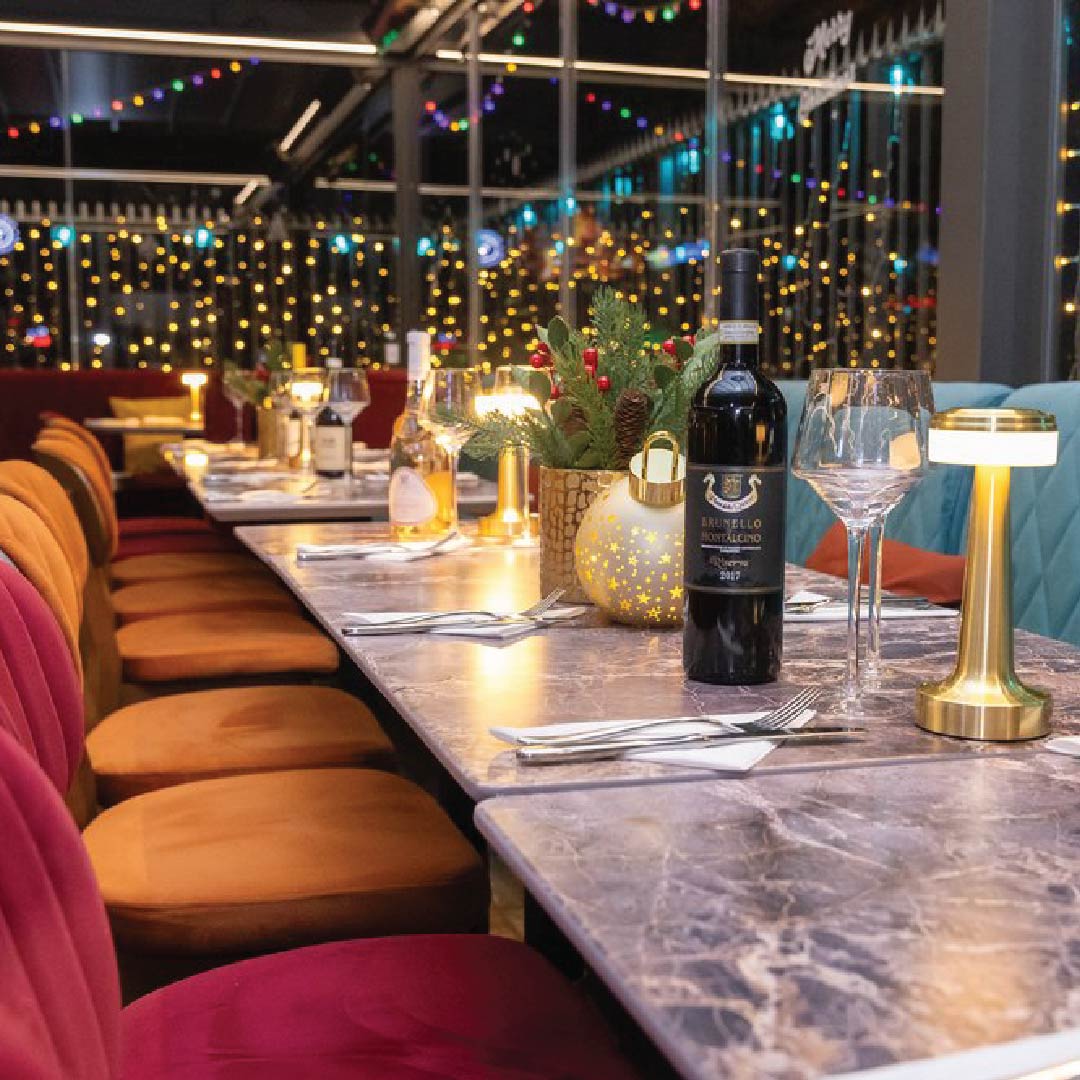 Upscale dining table setup with greenery centerpiece for elegant corporate events.