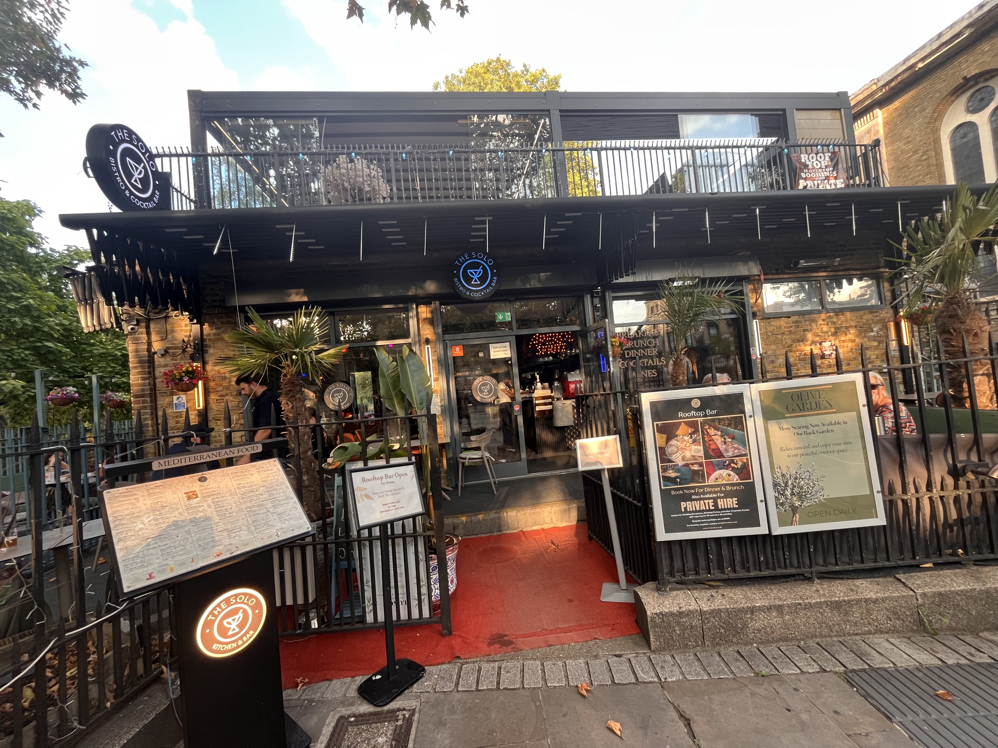 Vibrant venue entrance with outdoor seating, perfect for events and meetings.