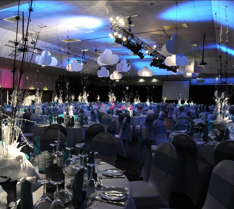 Banquet setup in Function Room with cloud decor and blue stage lighting for corporate gala events.