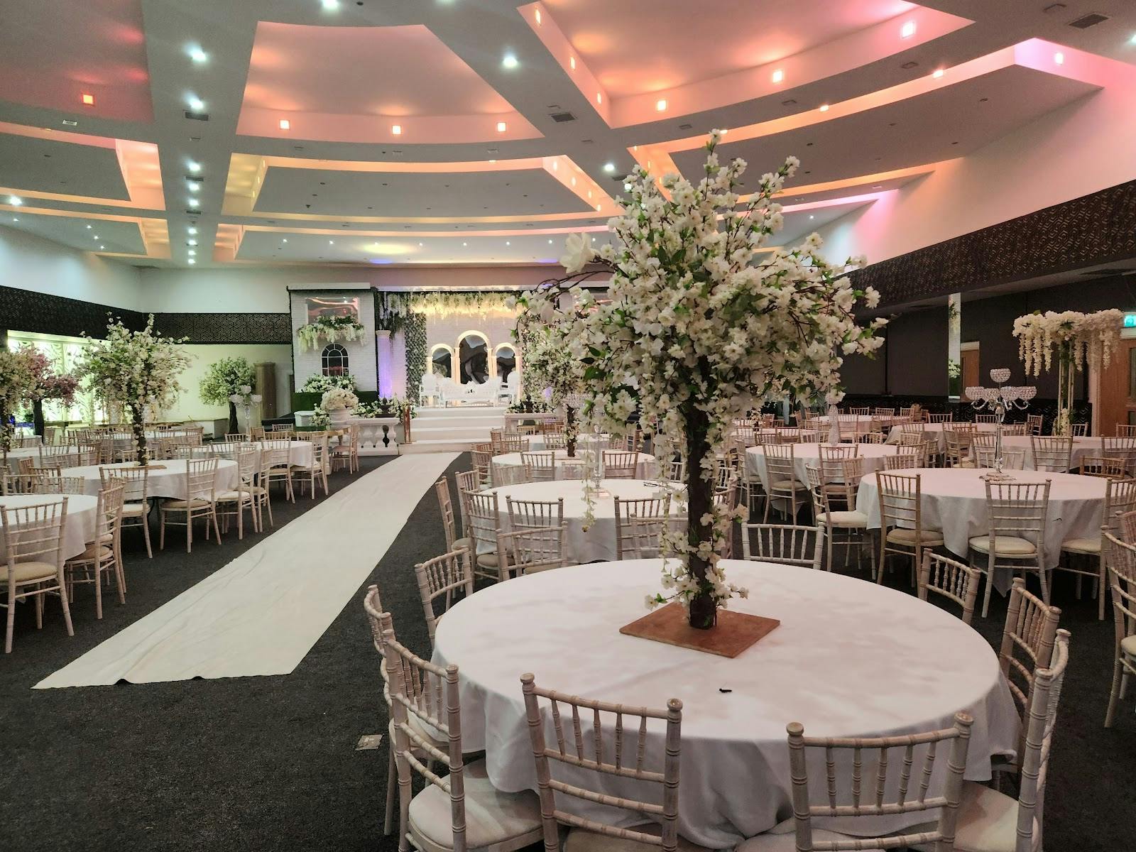 Wedding reception ballroom at Royal Shalimar with floral centerpieces, ideal for event planning.