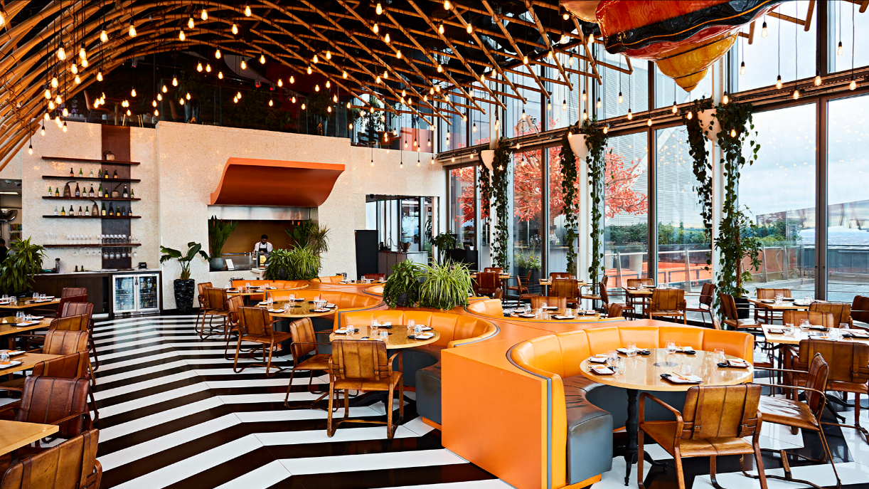 Vibrant Caravaggio restaurant with bold orange seating, ideal for events and gatherings.