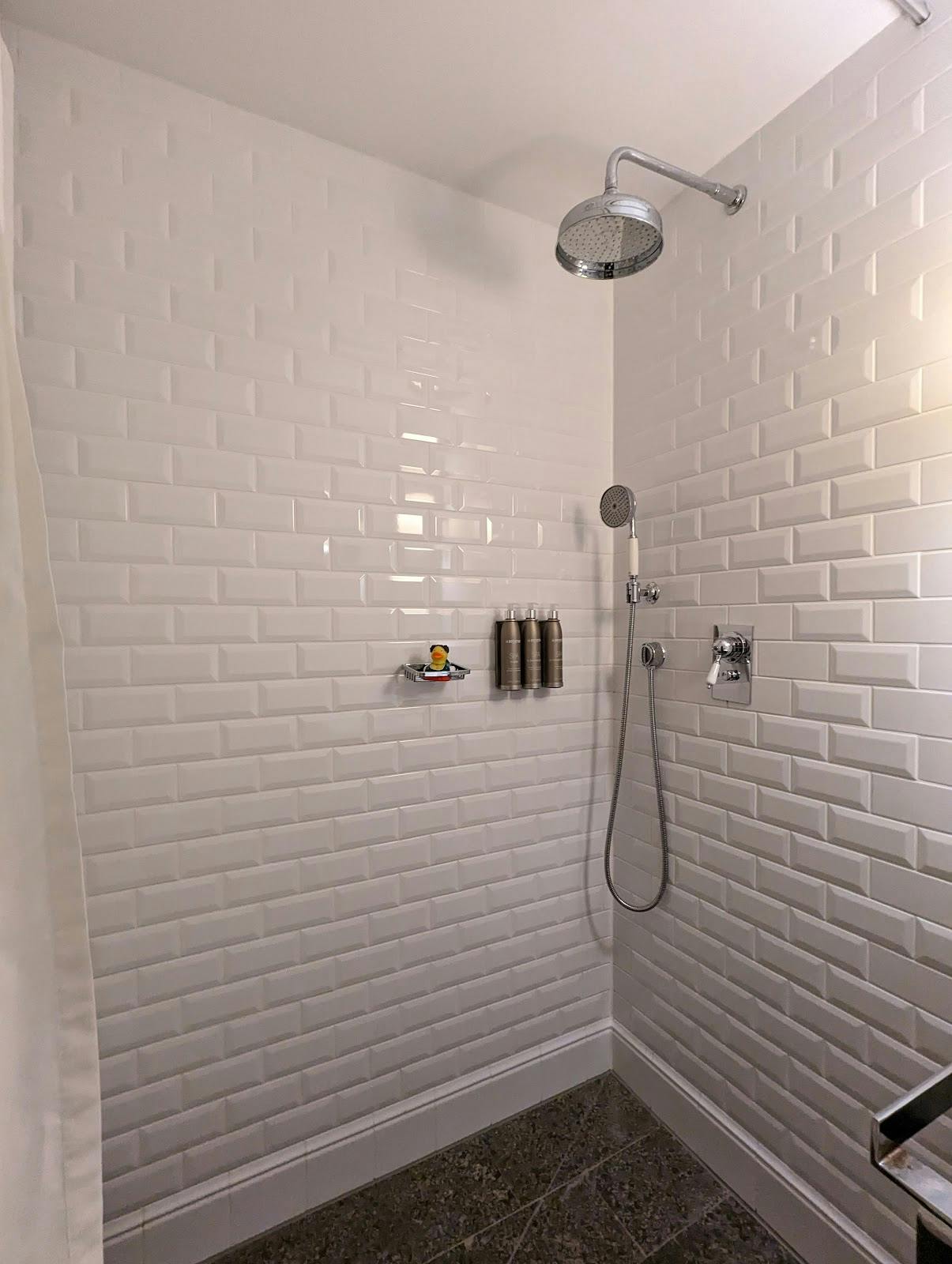 Modern bathroom with sustainable wall dispensers at LOUIS Hotel Bar & Lounge.