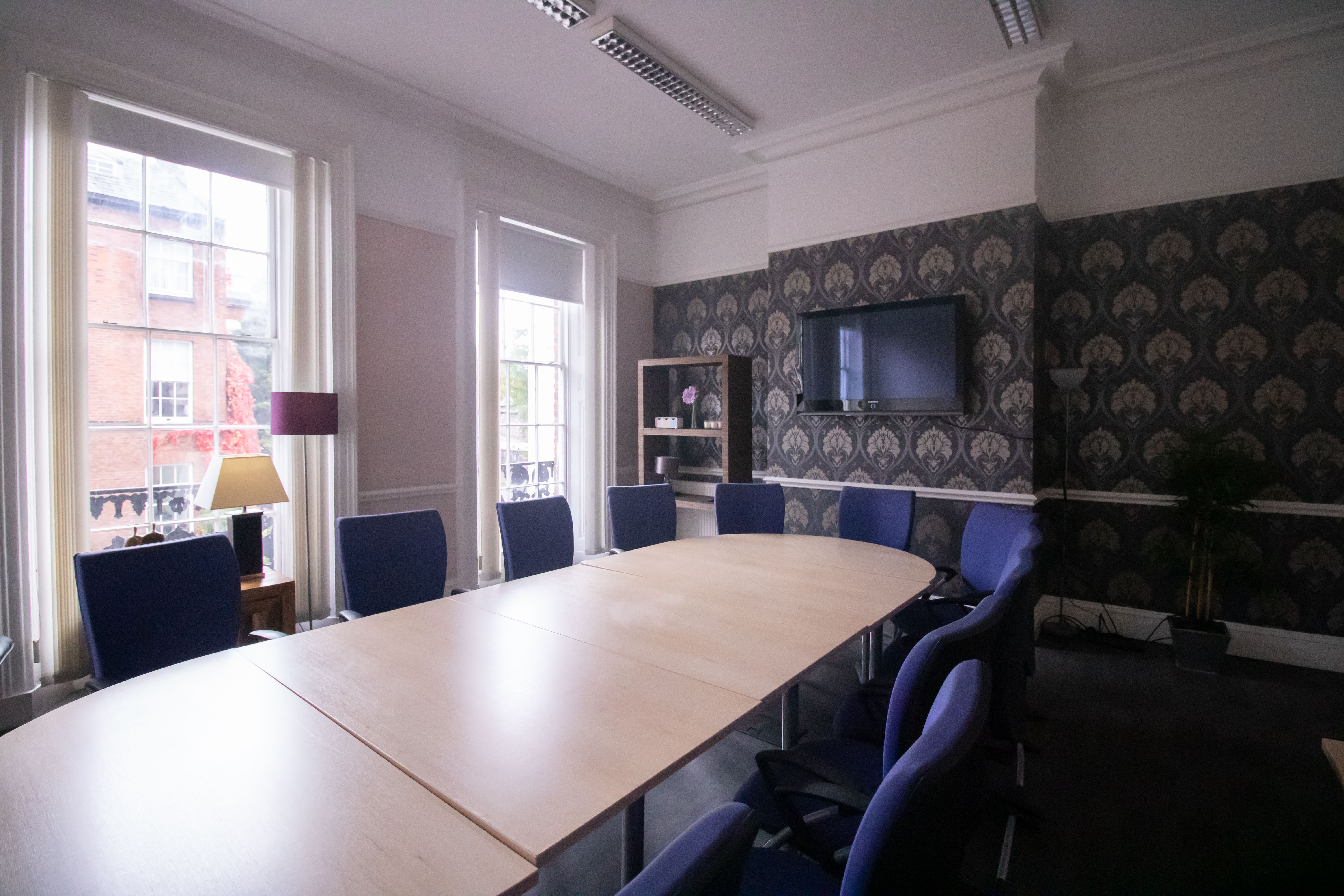 "Rodney Chambers Boardroom with oval table, blue chairs for corporate meetings and events."