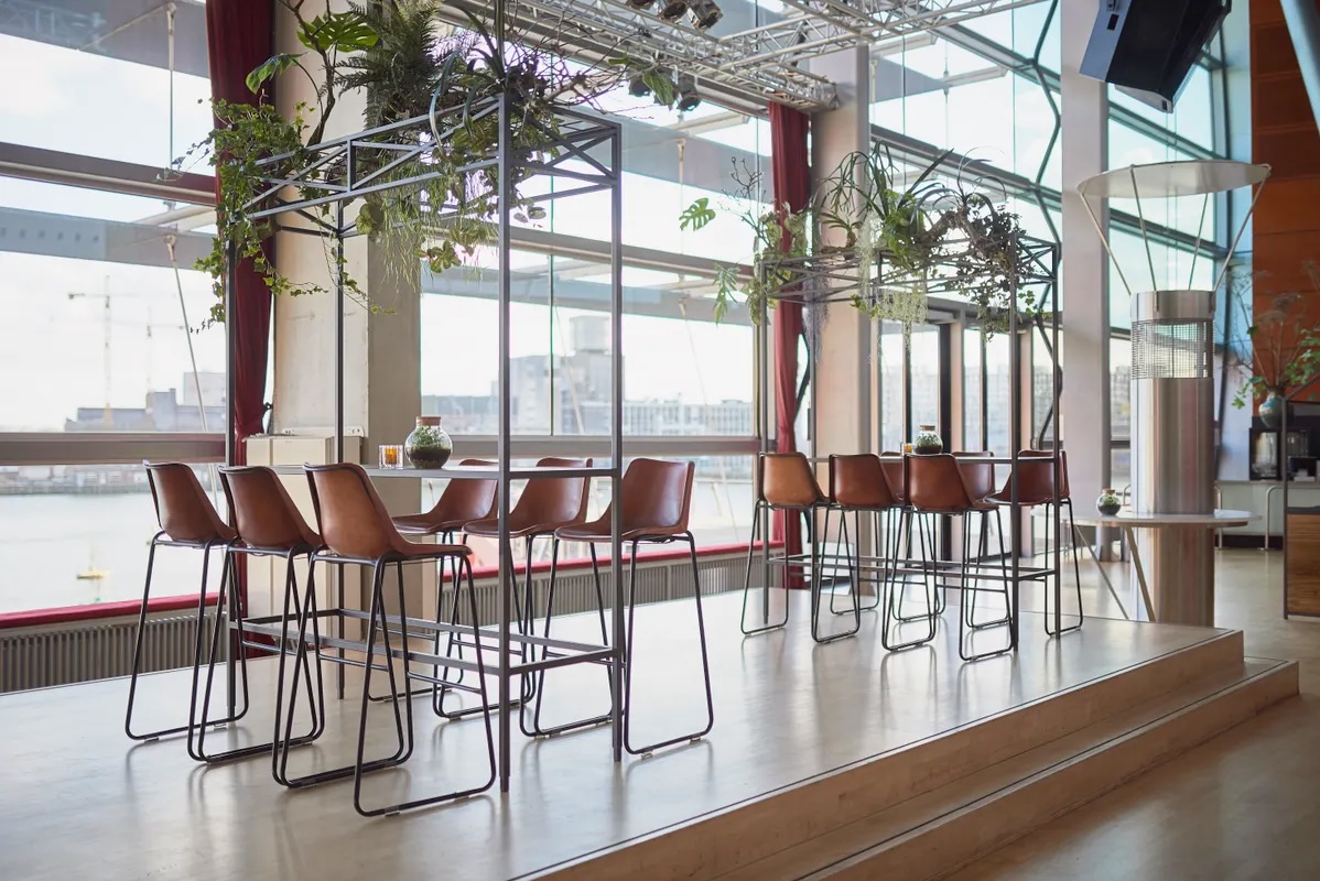 Rhine Foyer at New Luxor Theater: high-top breakout space with industrial decor for corporate events.