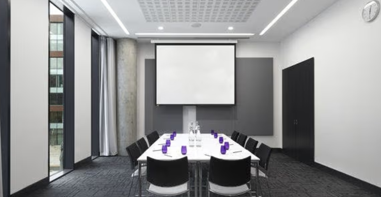 Modern meeting room in INNSIDE Manchester, ideal for presentations and professional gatherings.