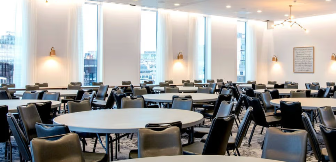 Versatile meeting space with round tables at voco Manchester City Centre for events.