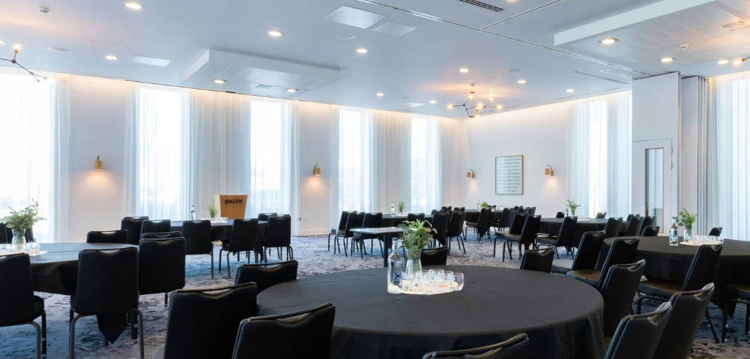 Modern meeting space in voco Manchester with large windows, ideal for events and networking.
