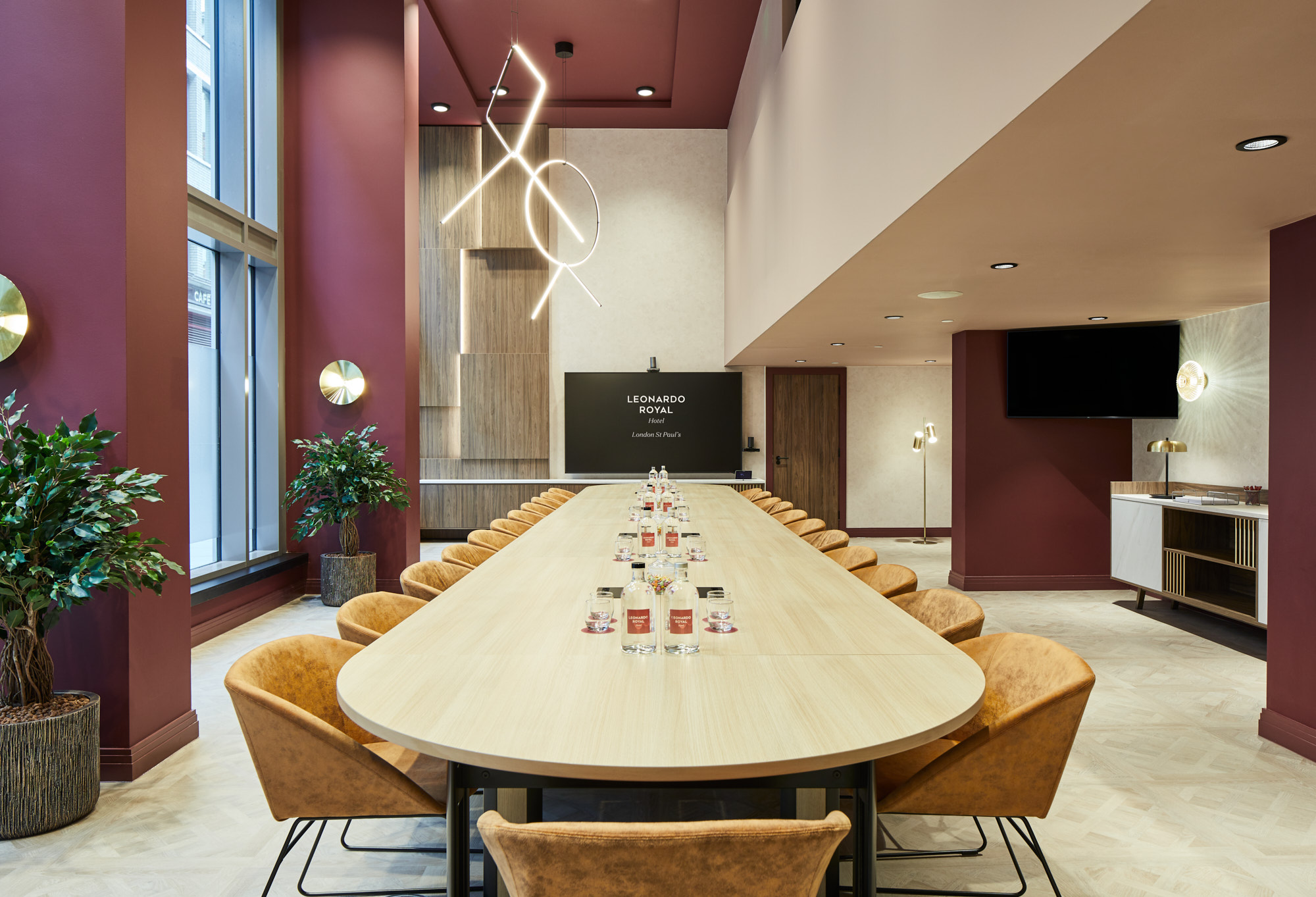 Modern meeting room at Leonardo Royal Hotel London, featuring an elongated table for workshops.
