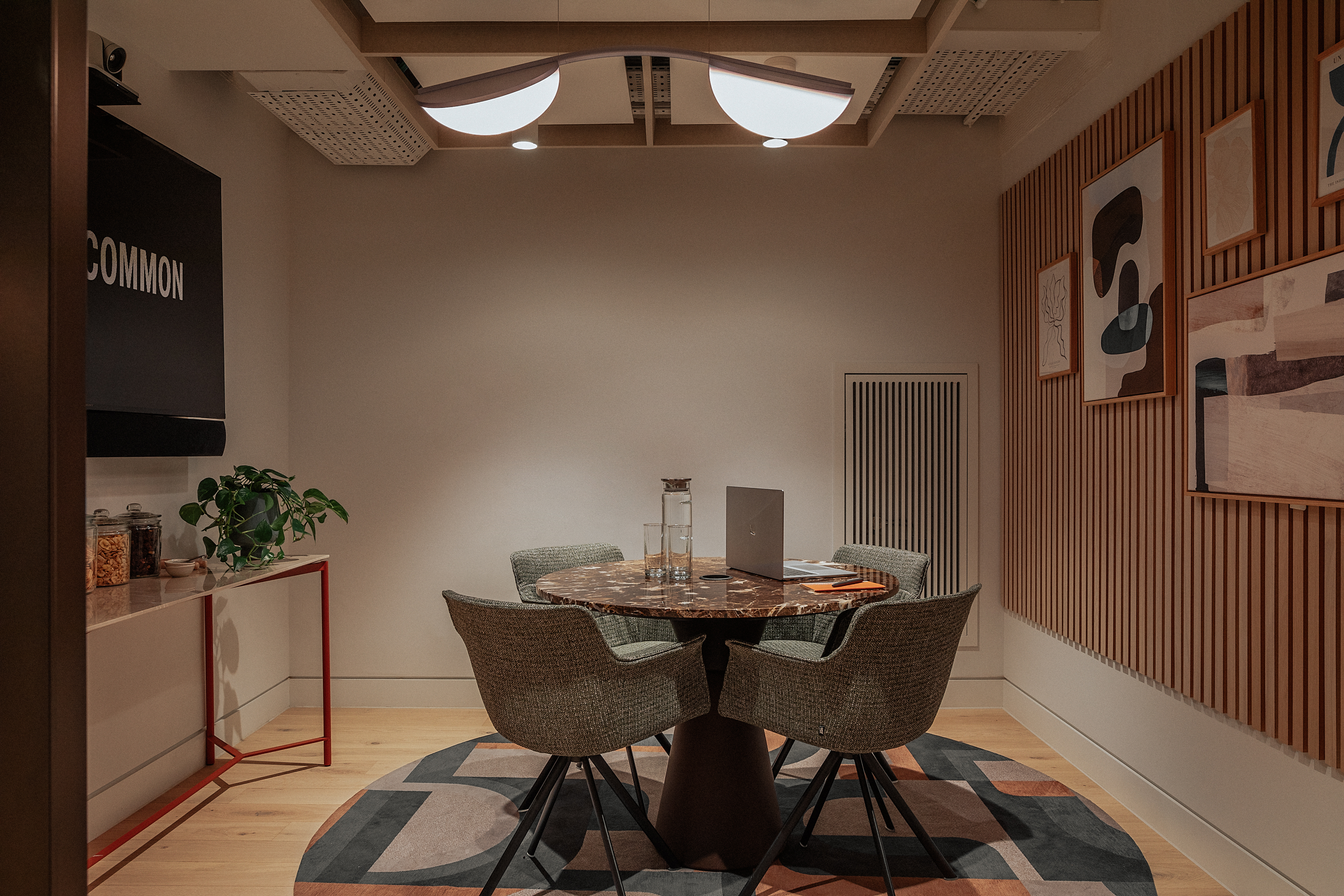 Modern meeting room with circular table, ideal for workshops and brainstorming sessions.