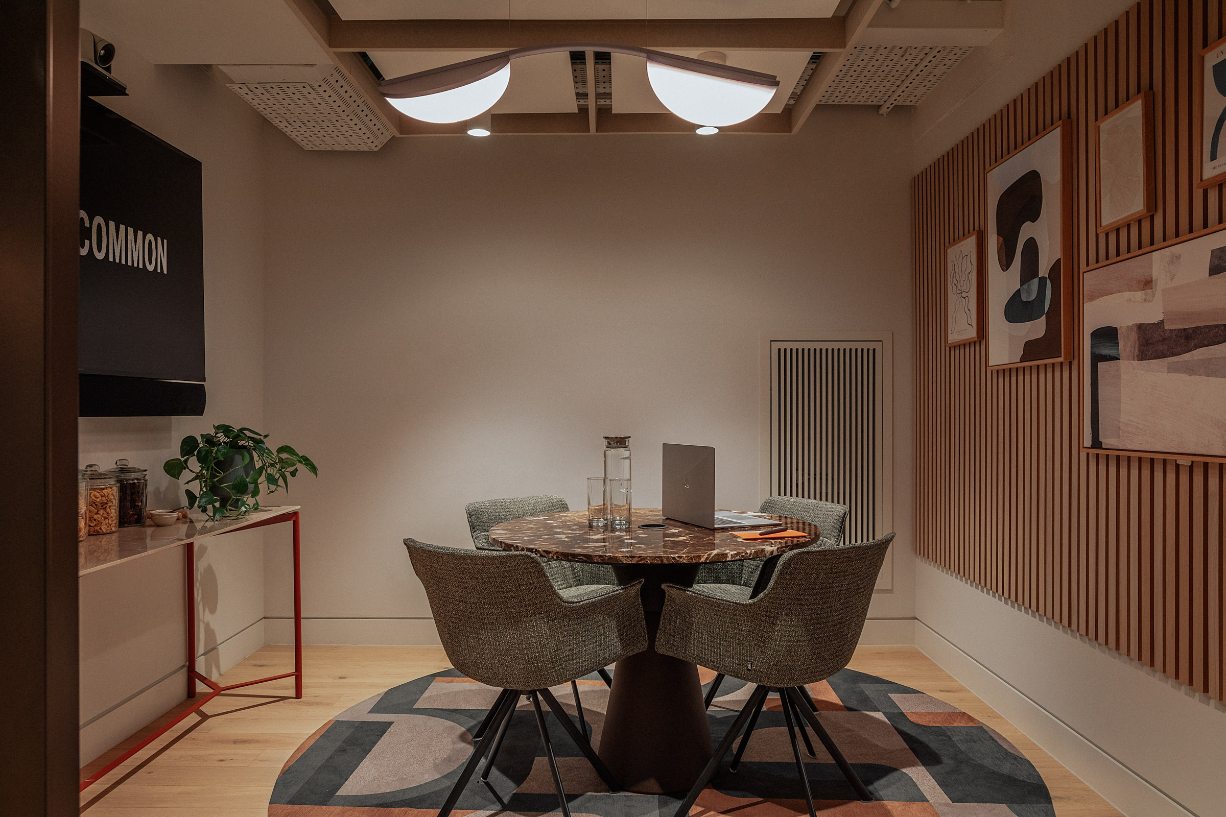 Modern meeting room with round table, ideal for collaborations and brainstorming sessions.