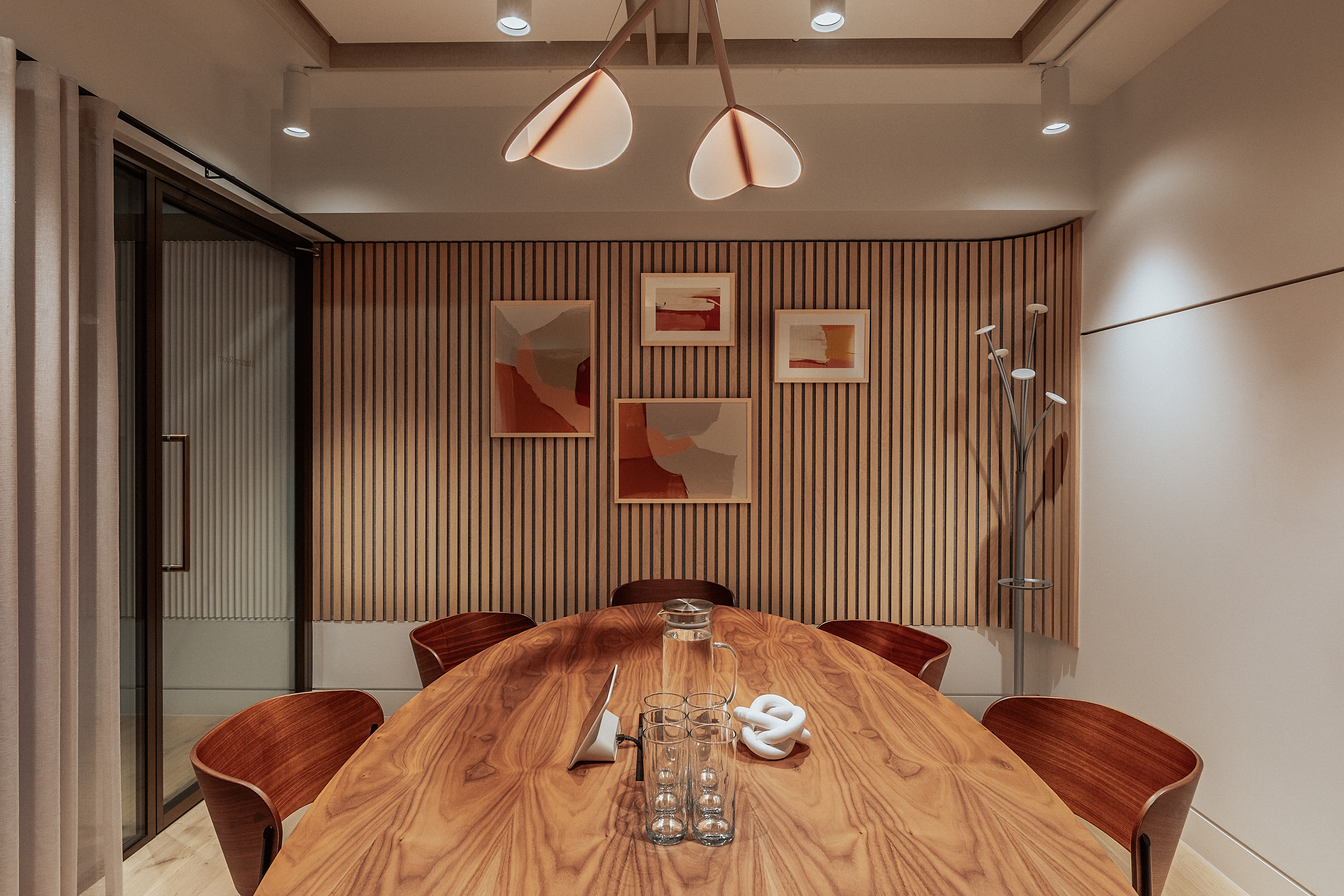 Modern meeting room with wooden table, perfect for intimate gatherings and brainstorming.