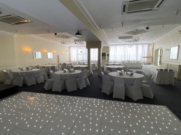 Elegant event space with round tables, ideal for weddings and corporate events.
