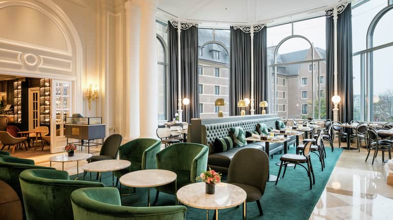 Elegant banquet hall at Hilton Brussels, featuring plush seating for networking events.