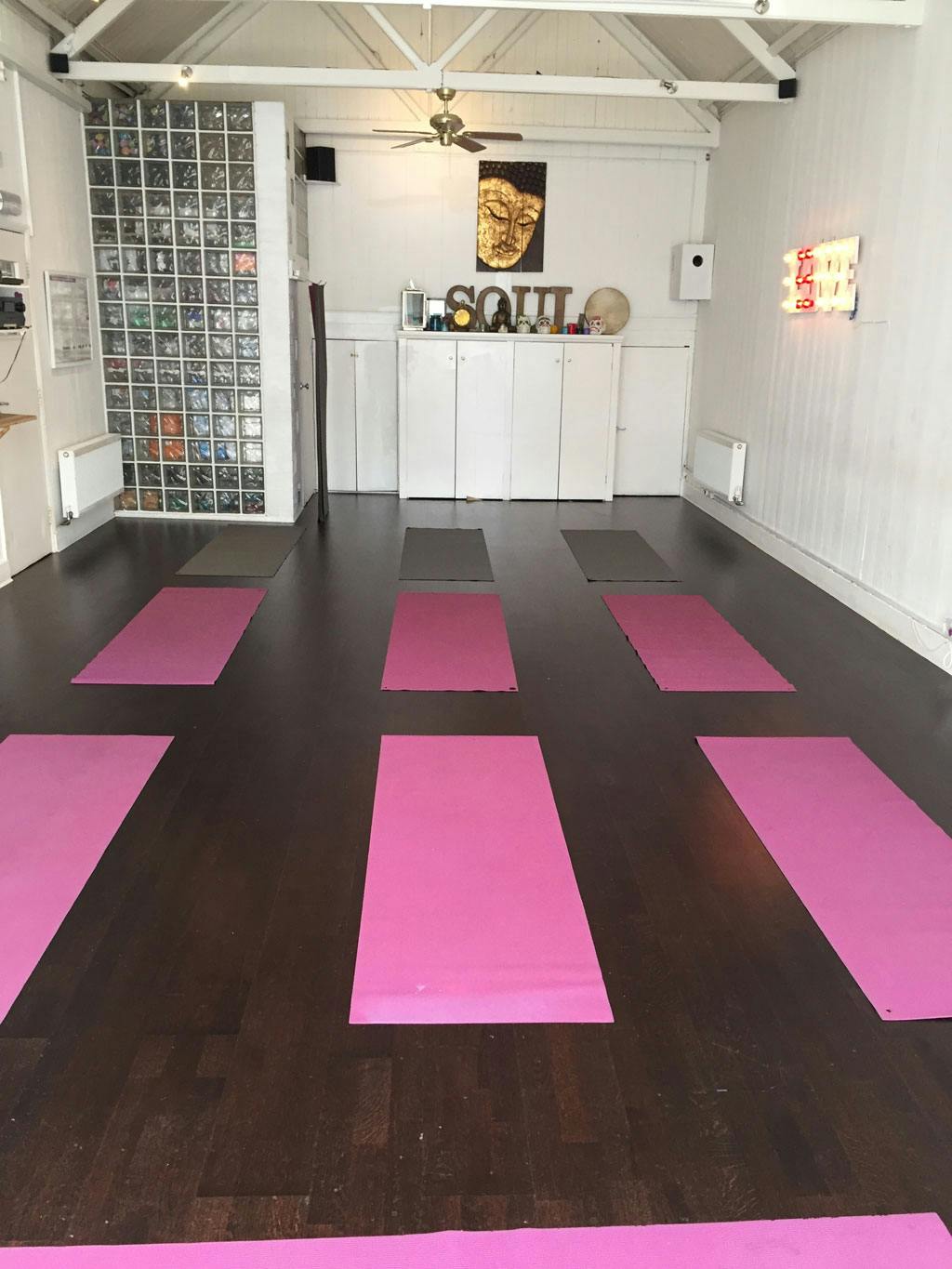 Spacious yoga studio with pink mats for wellness retreats and mindfulness workshops.