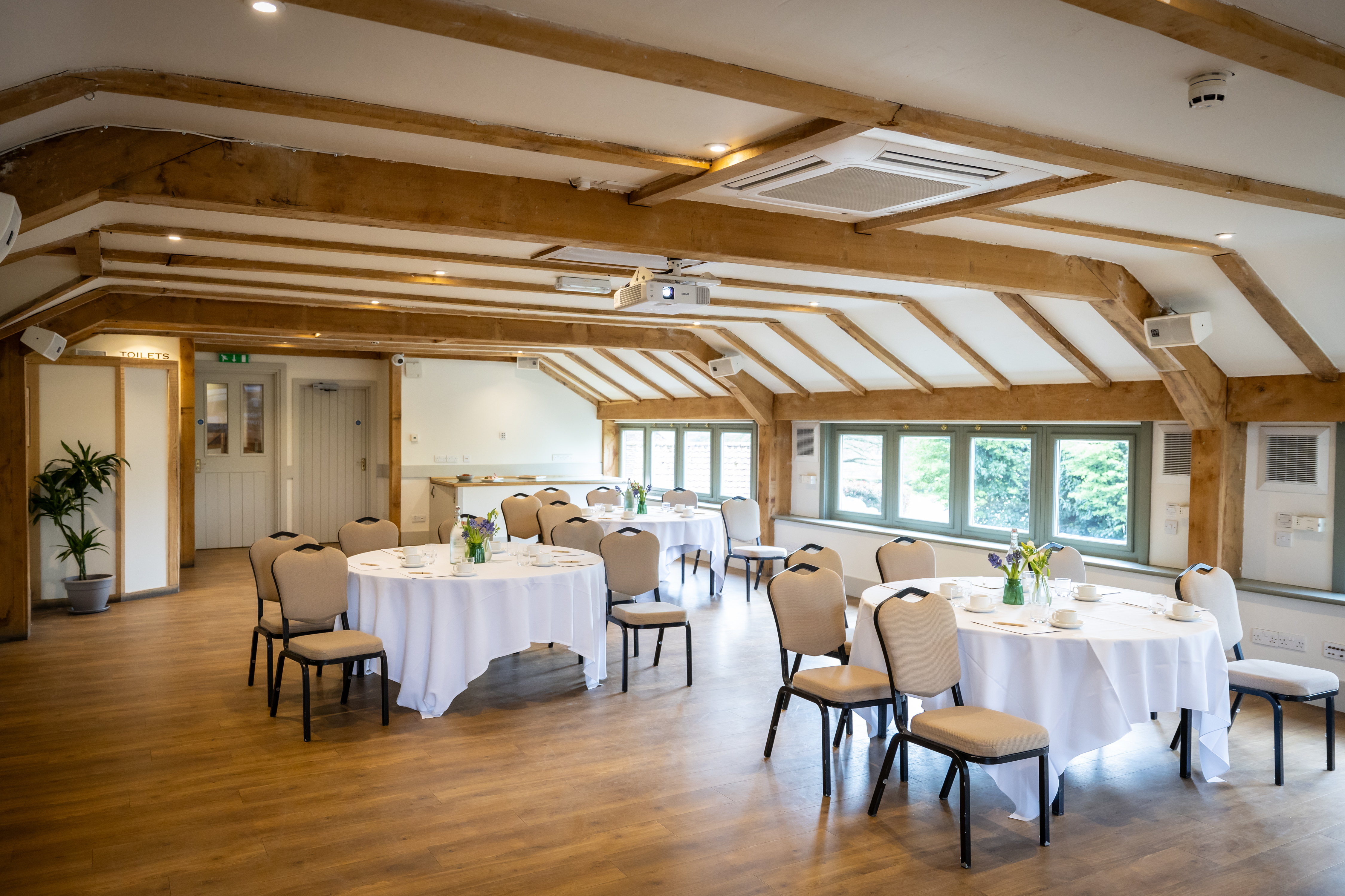 Millstream Room at Tewinbury Farm Hotel, bright space with wood beams for events and meetings.