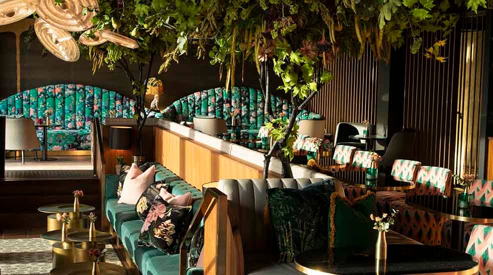 Vibrant restaurant event space at Clarion Hotel with lush greenery for gatherings.