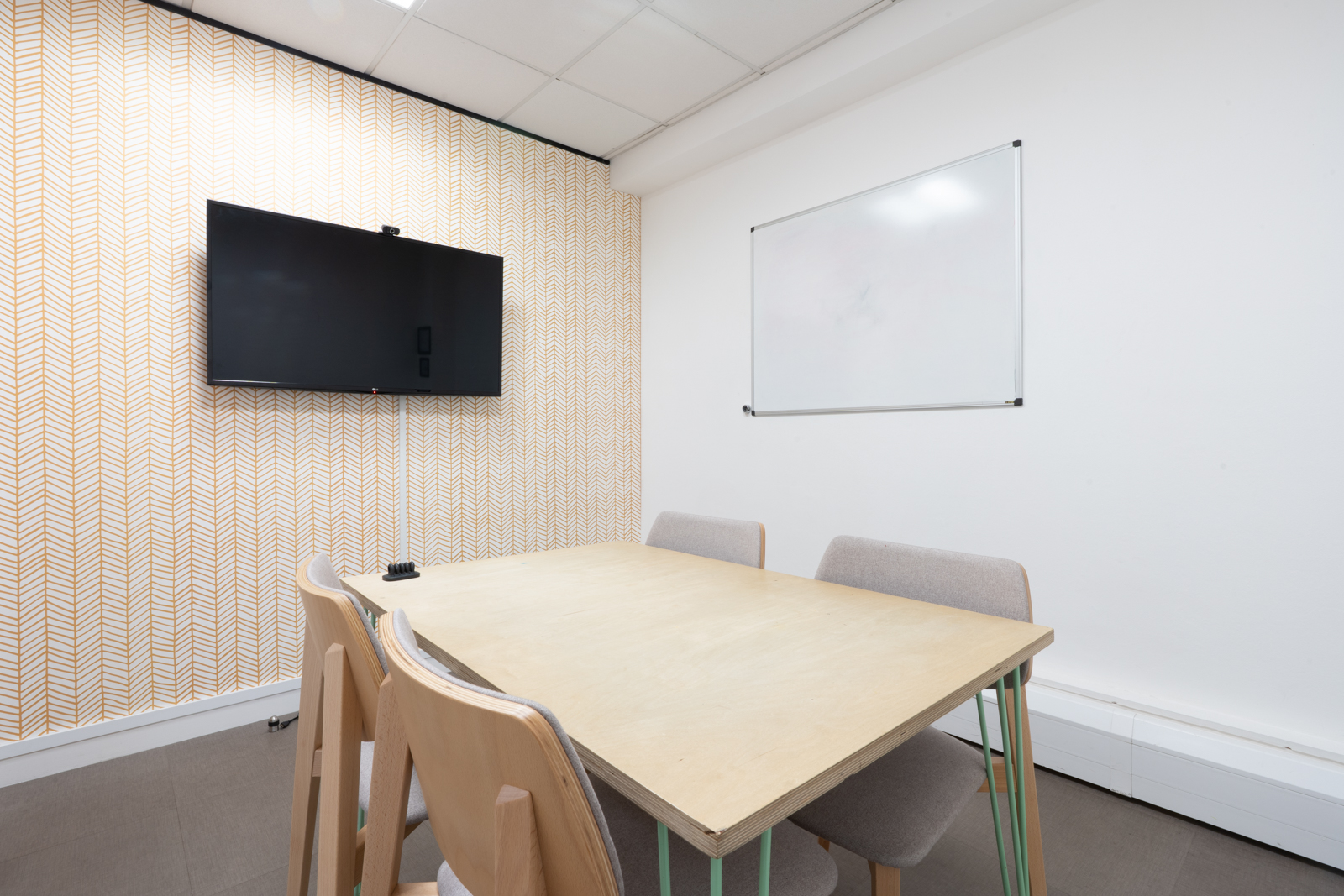 "Functional meeting room at Runway East with large table and whiteboard for workshops."