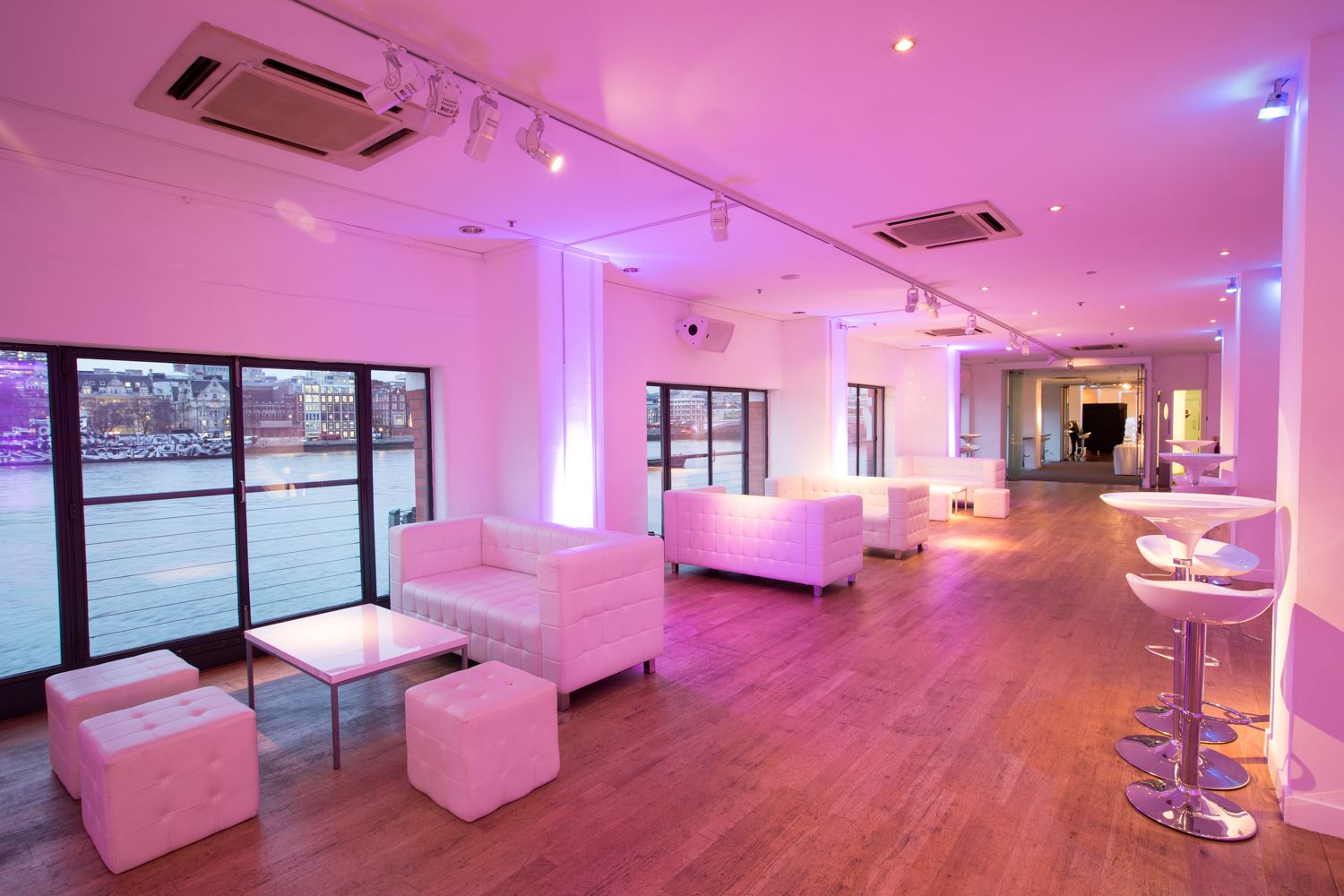 Modern event space with waterfront view, perfect for networking and cocktails.