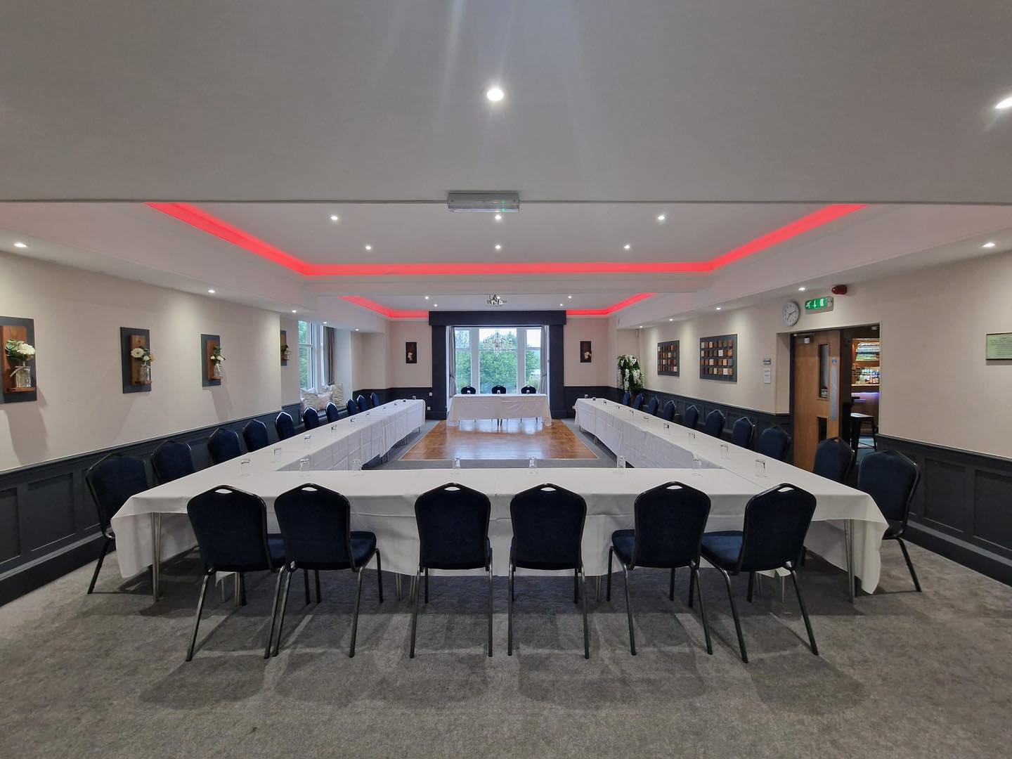 U-shape boardroom at The Mill House with red accent lighting for corporate meetings and events.