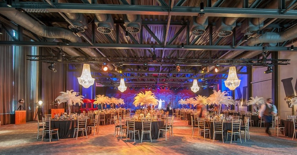 Elegant Rum Warehouse event space with black tablecloths and feather centerpieces.