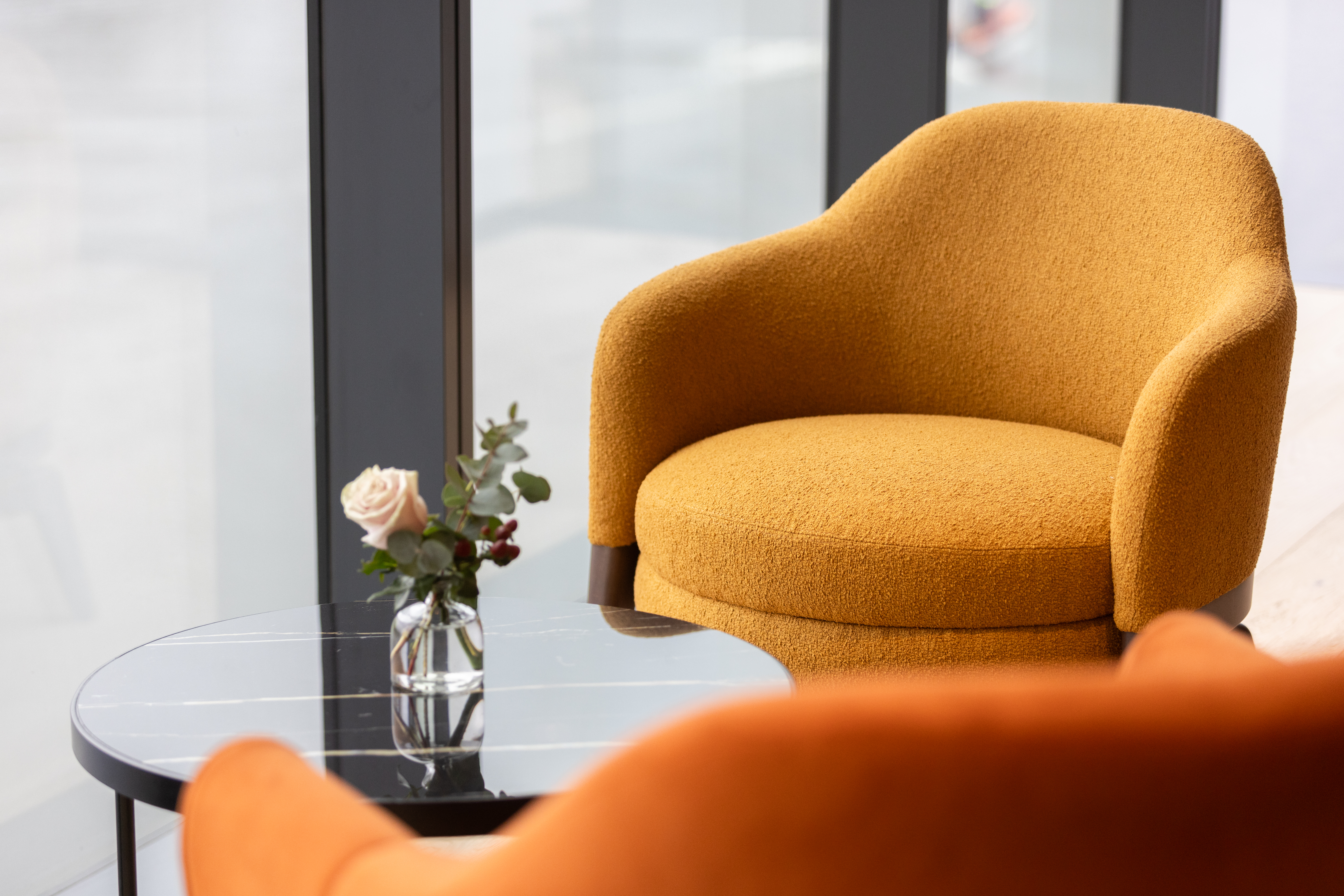 Stylish seating area with vibrant orange chair for networking events at Fulham Pier.