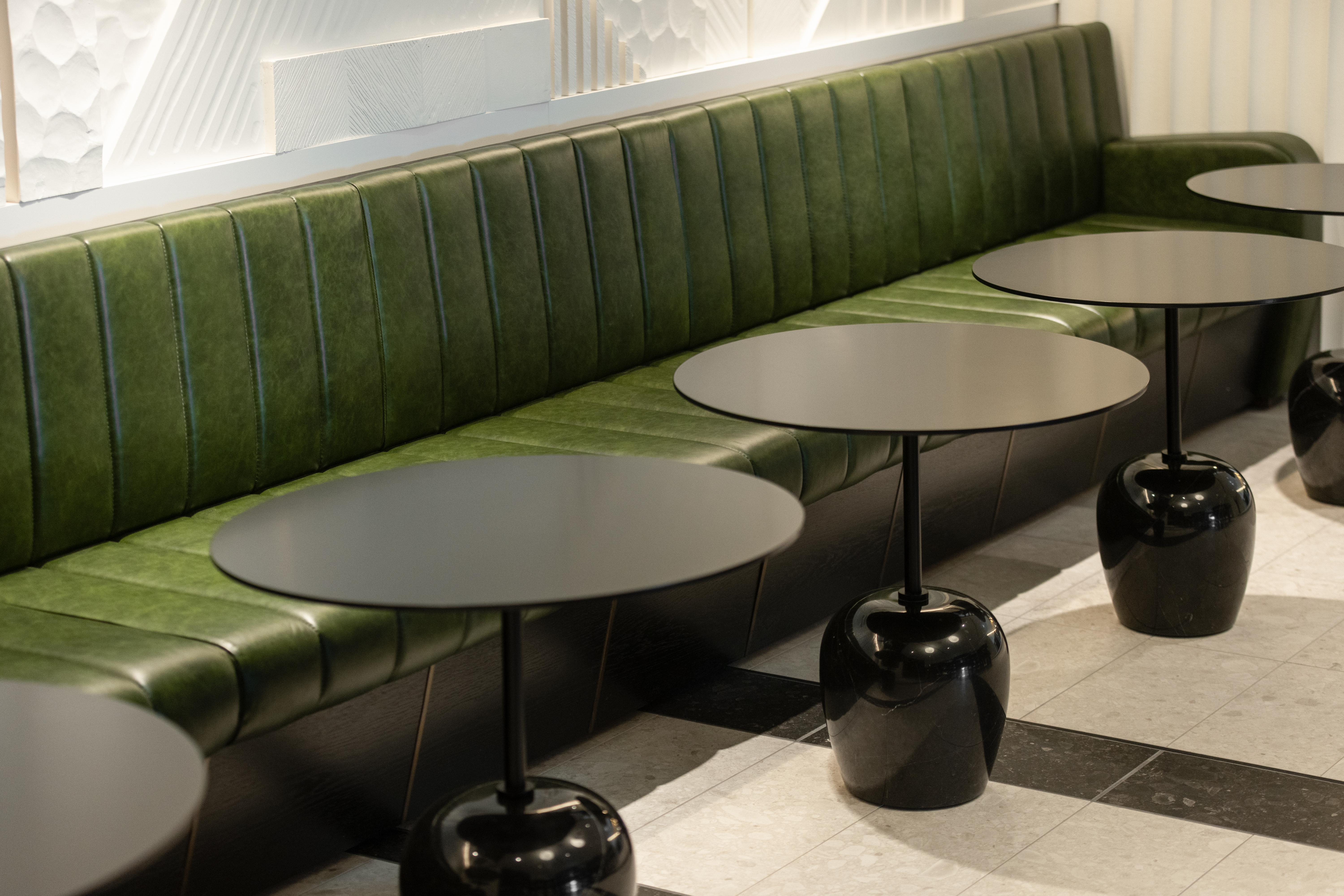 Sleek Thames Bar seating with green benches, ideal for casual meetings and networking events