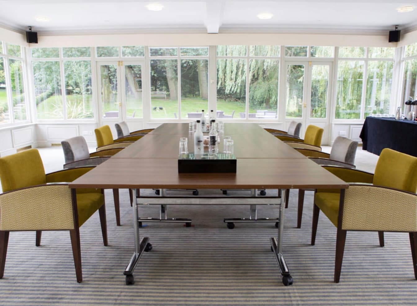 The Garden Room boardroom at Quy Mill Hotel, featuring natural light for corporate meetings.